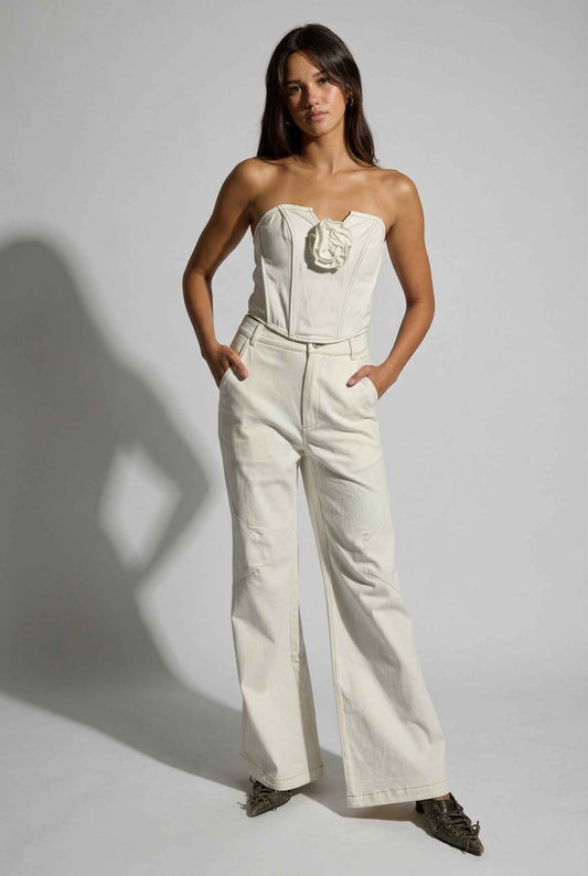 Model wearing Odette Top in White Cotton Denim Strapless Rosette Bustier with matching bootleg jeans and pointed heels