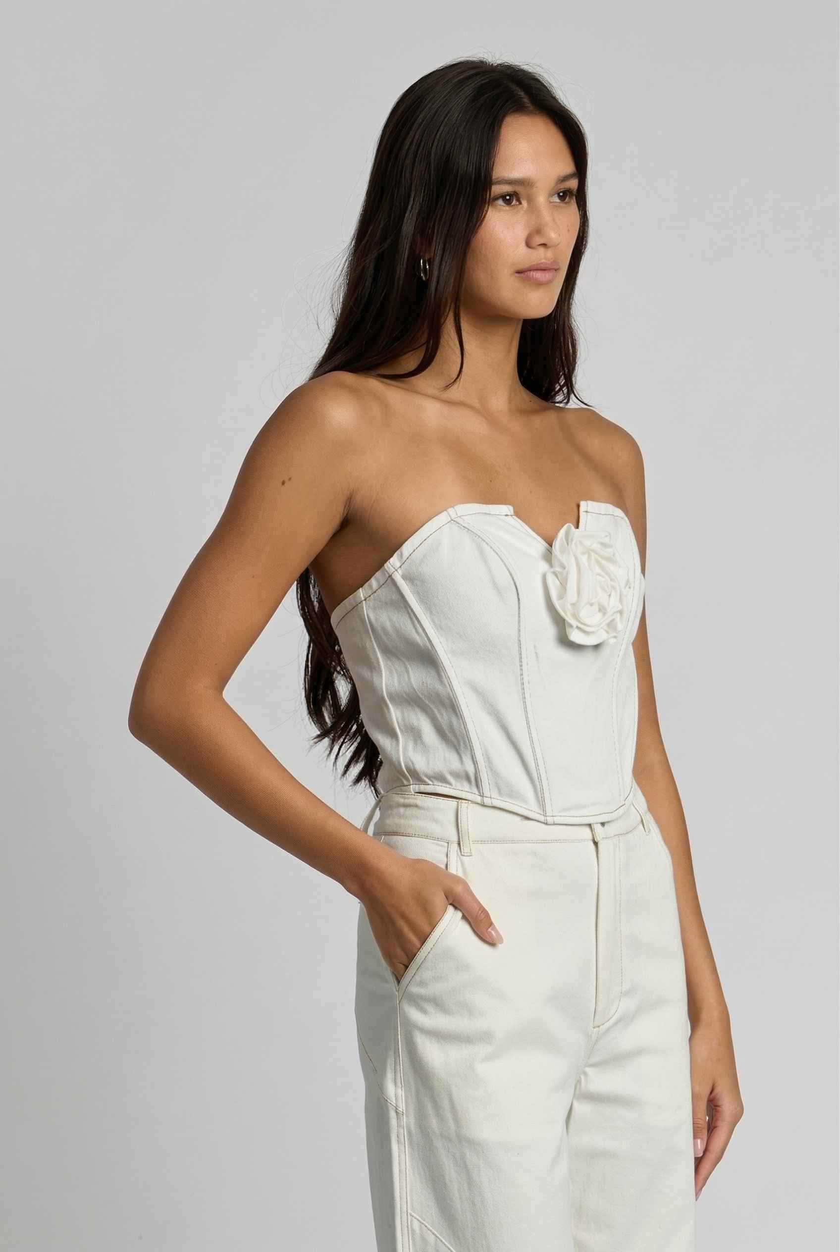 Model wearing Odette Top in White Cotton Denim Strapless Rosette Bustier with matching bootleg jeans 