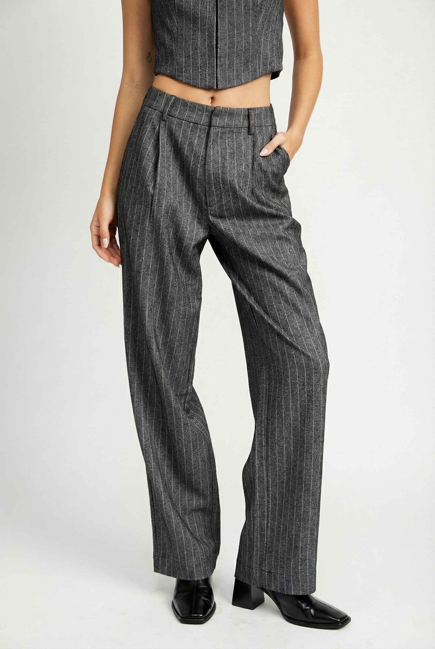 Model wearing Hayden Pants in Grey Pinstripe Wide-Leg Trousers with matching vest top and chunky heels