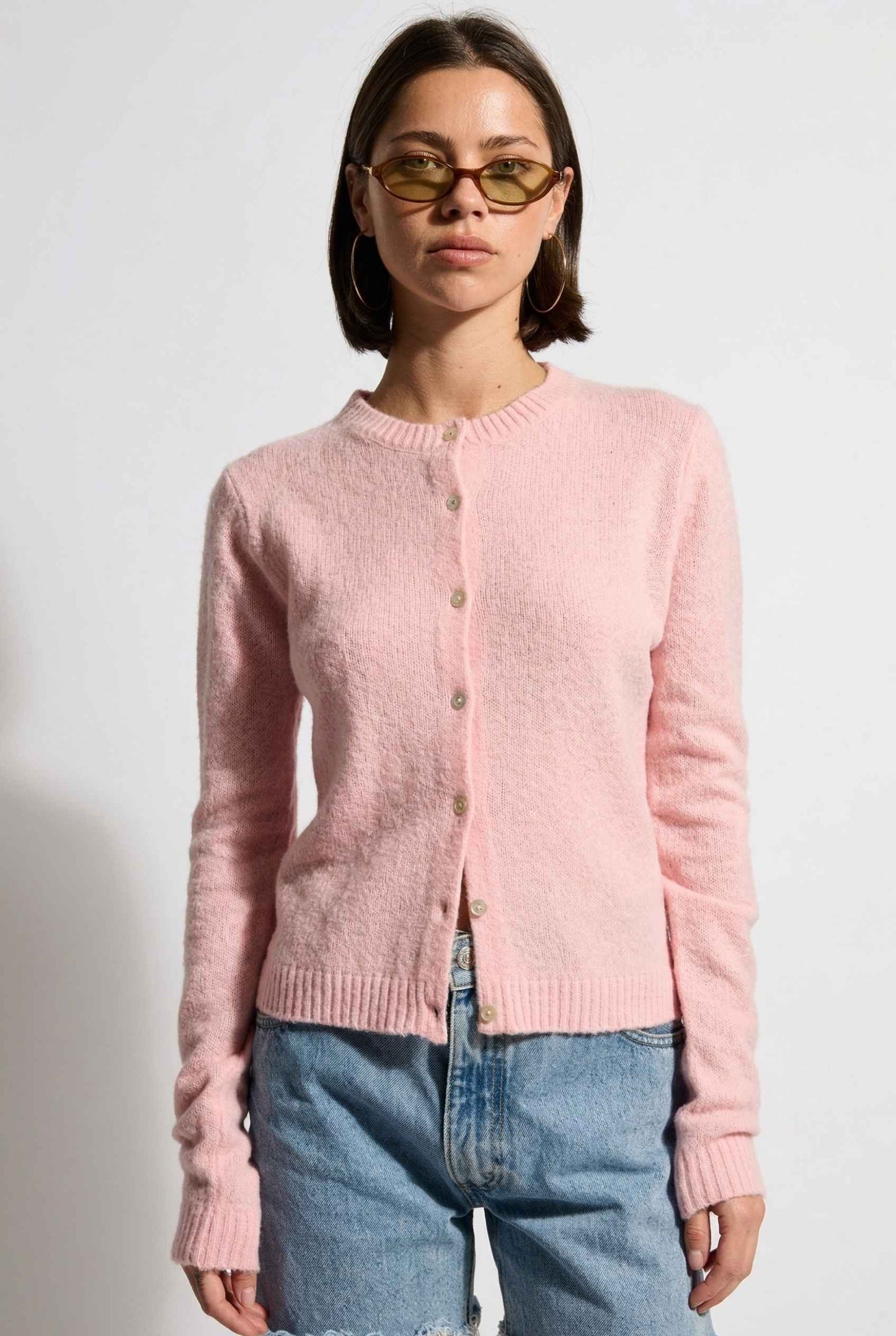 Model wearing Penelope Top in Pink Soft Wool-Blend Crew Neck Button-Up Cardigan with denim shorts