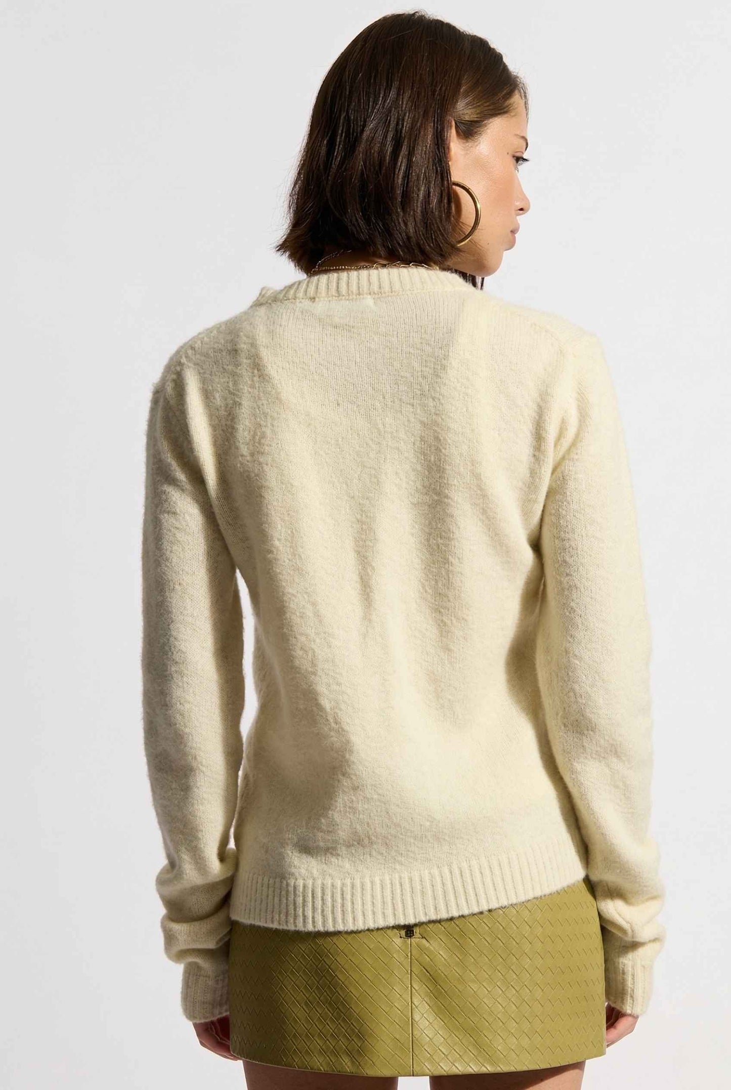 Model wearing Penelope Top in Yellow Soft Wool-Blend Crew Neck Button-Up Cardigan with leather mini skirt