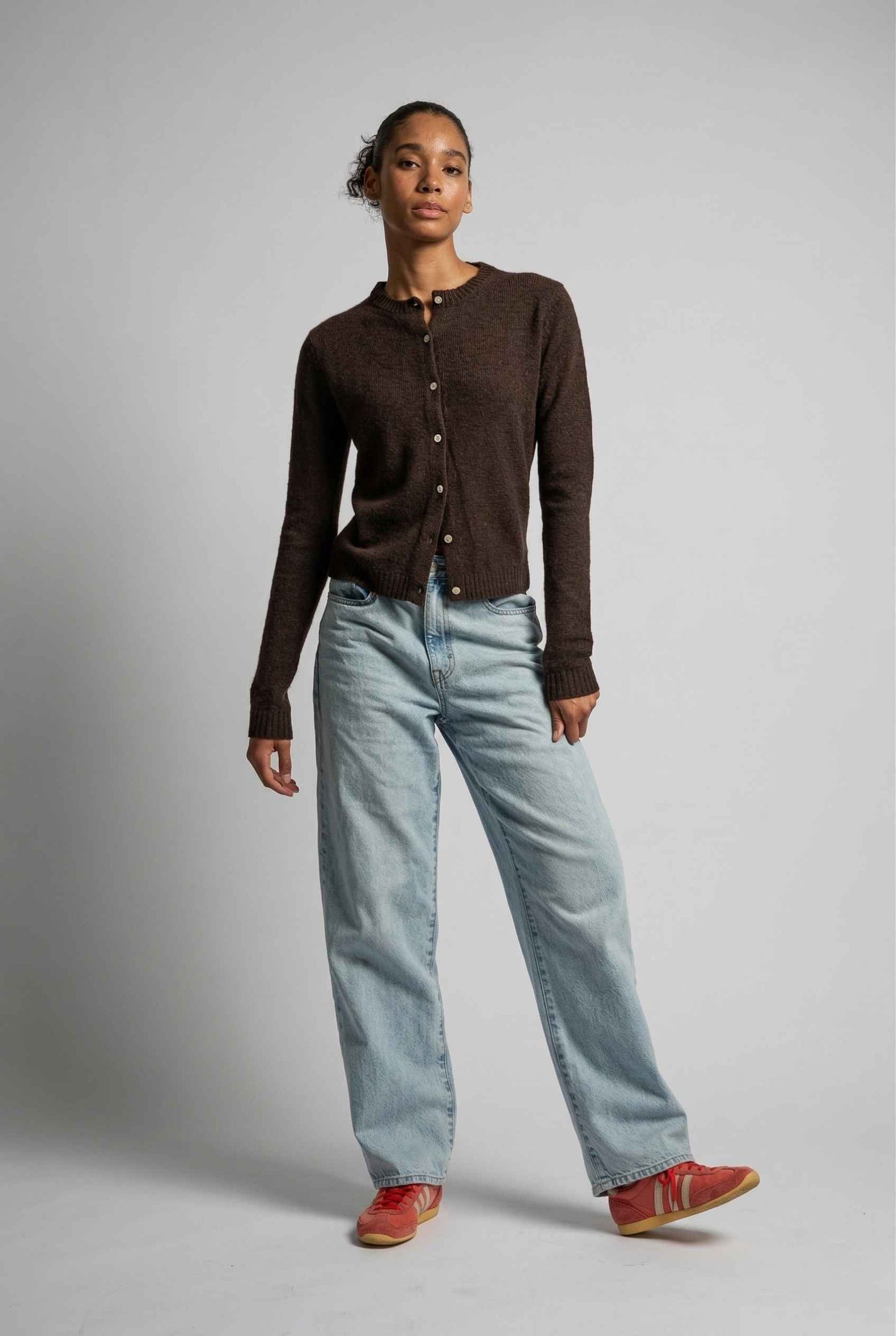 Model wearing Penelope Top in Chocolate Soft Wool-Blend Crew Neck Button-Up Cardigan with jeans and sneakers