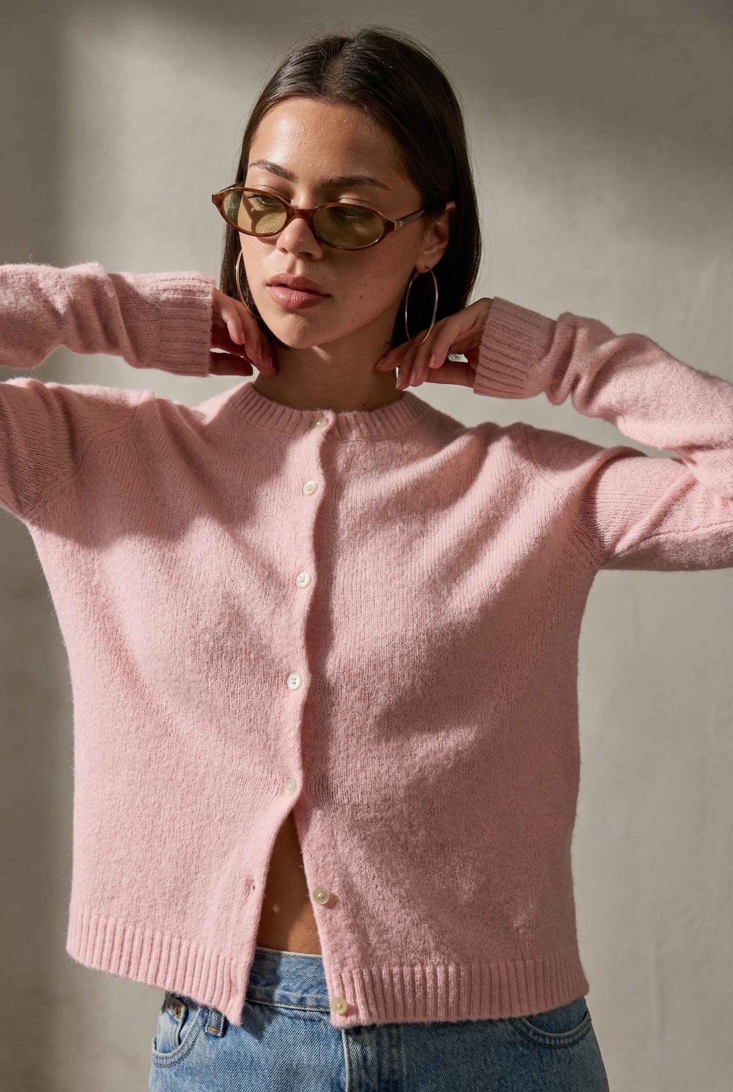 Model wearing Penelope Top in Pink Soft Wool-Blend Crew Neck Button-Up Cardigan with denim shorts 