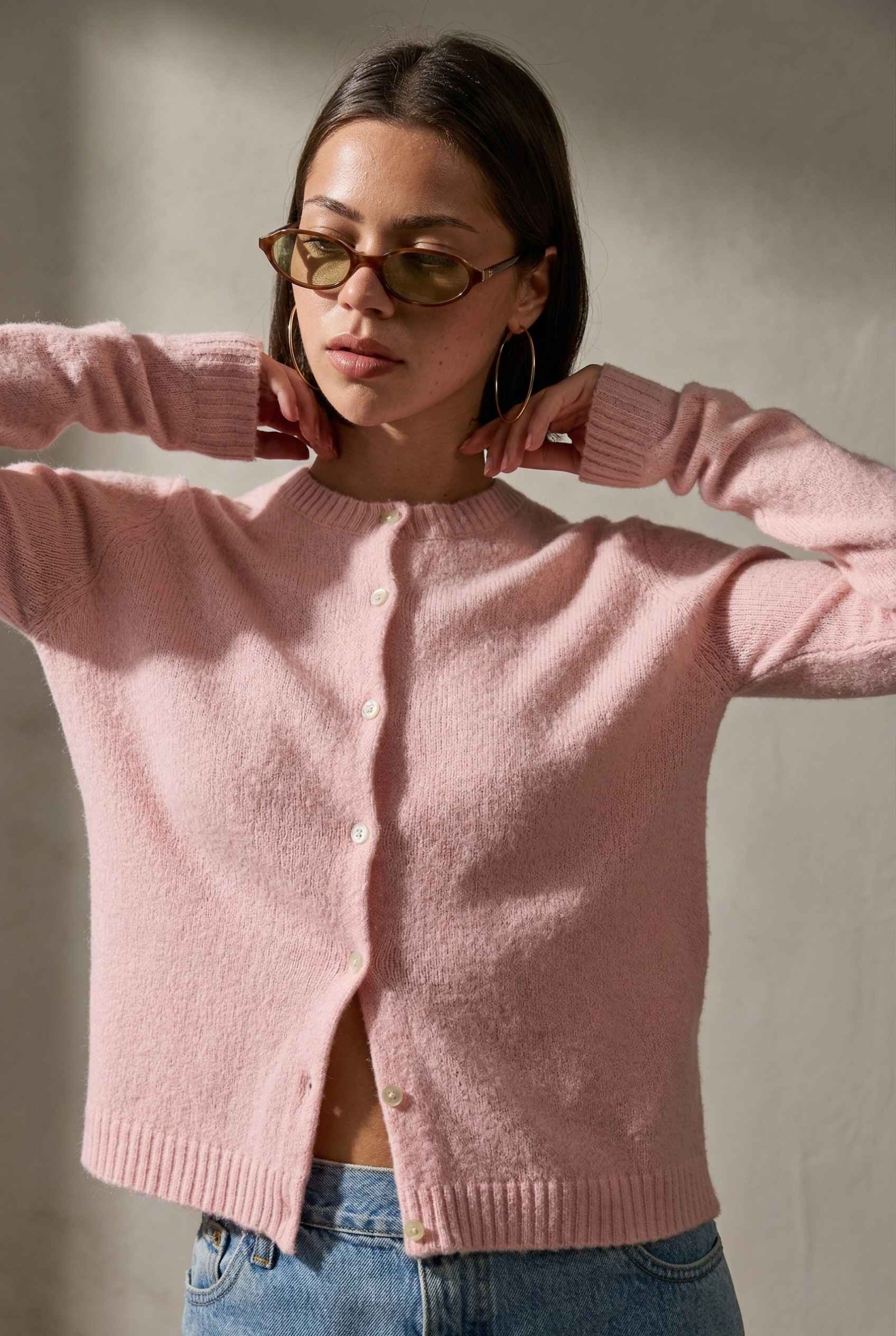 Model wearing Penelope Top in Pink Soft Wool-Blend Crew Neck Button-Up Cardigan with denim shorts 