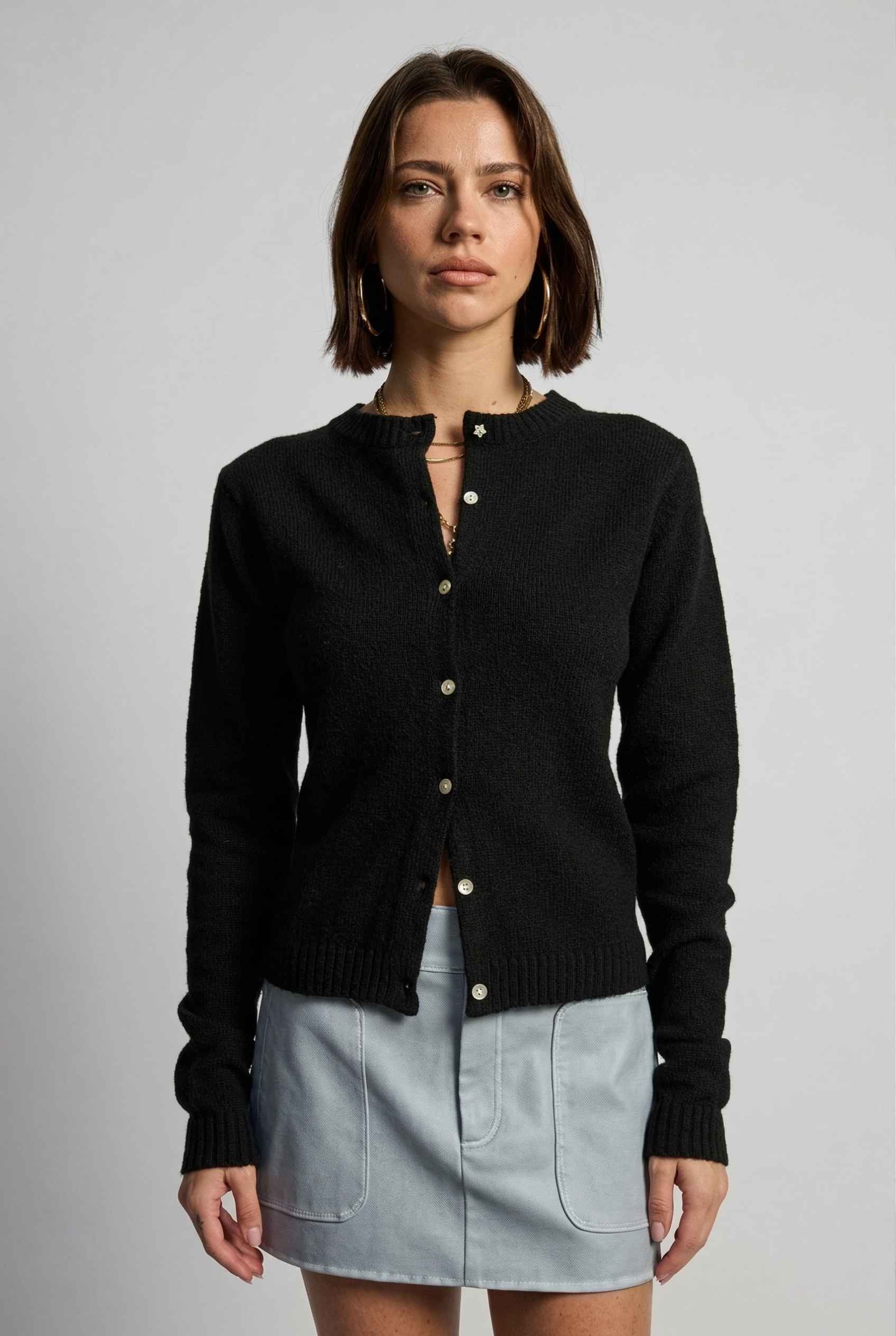 Model wearing Penelope Top in Black Soft Wool-Blend Crew Neck Button-Up Cardigan with cargo mini skirt