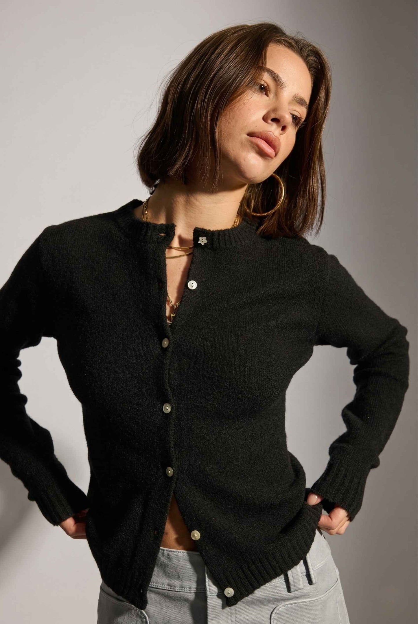 Model wearing Penelope Top in Black Soft Wool-Blend Crew Neck Button-Up Cardigan with cargo mini skirt 