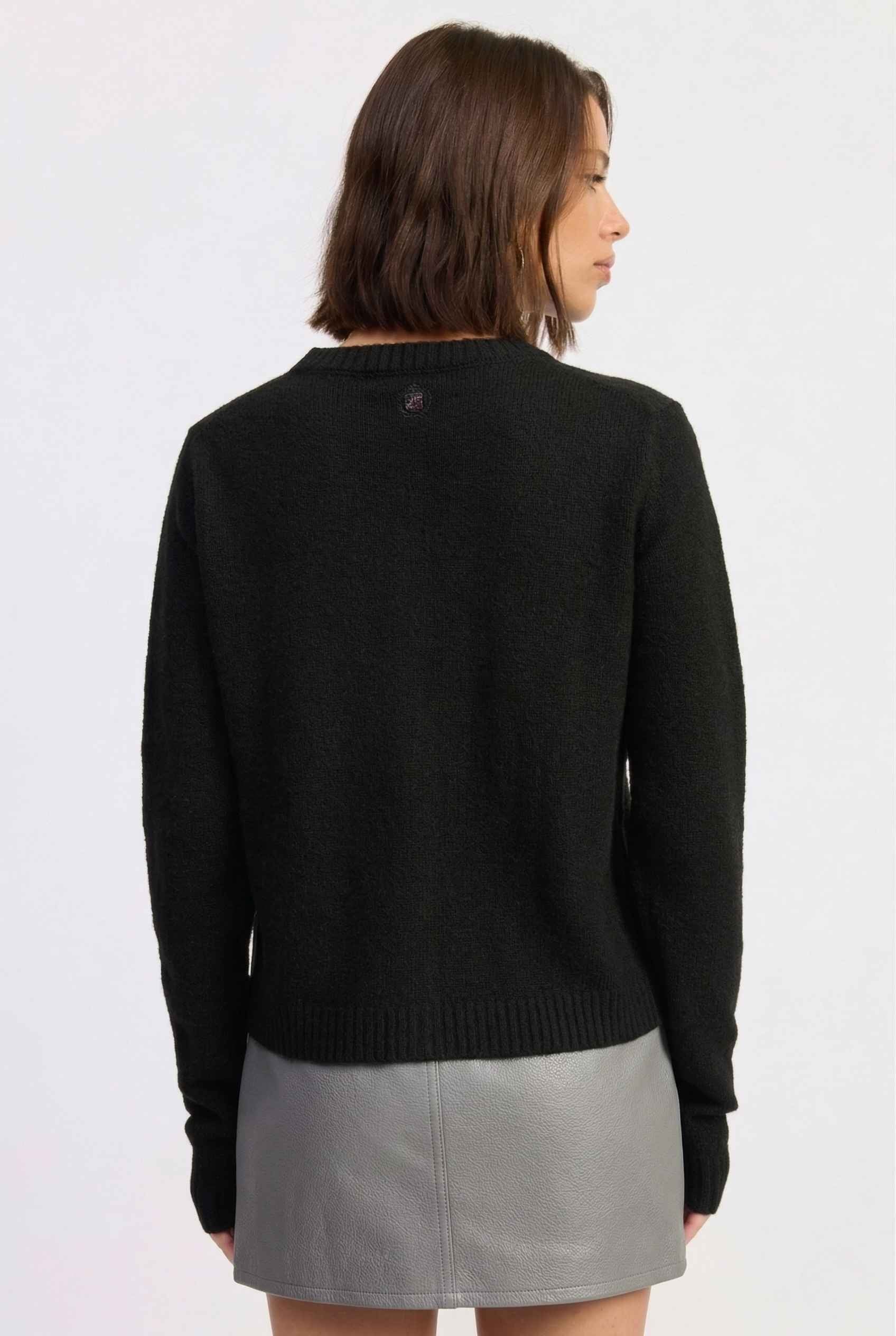 Model wearing Penelope Top in Black Soft Wool-Blend Crew Neck Button-Up Cardigan with cargo mini skirt 