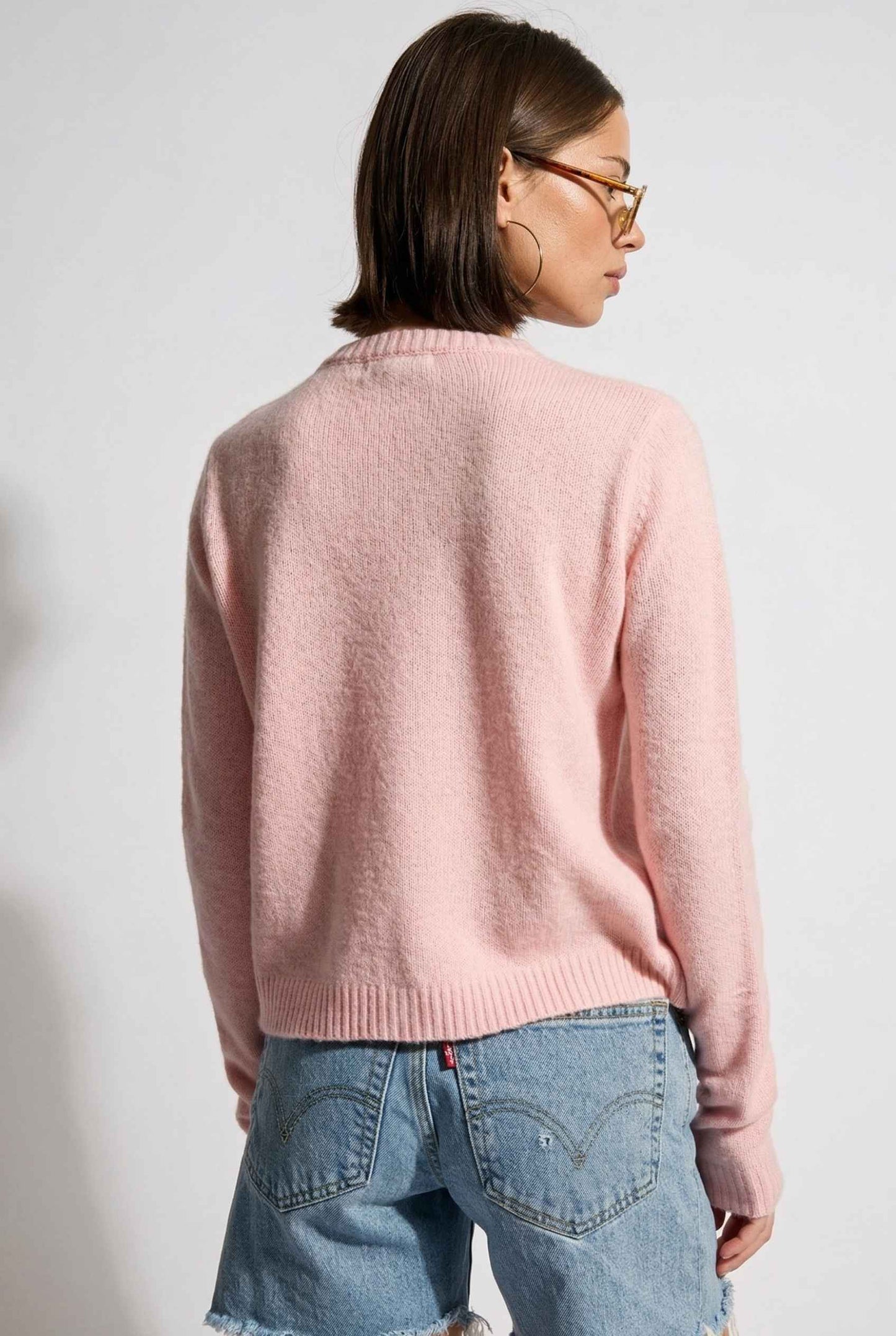 Model wearing Penelope Top in Pink Soft Wool-Blend Crew Neck Button-Up Cardigan with denim shorts