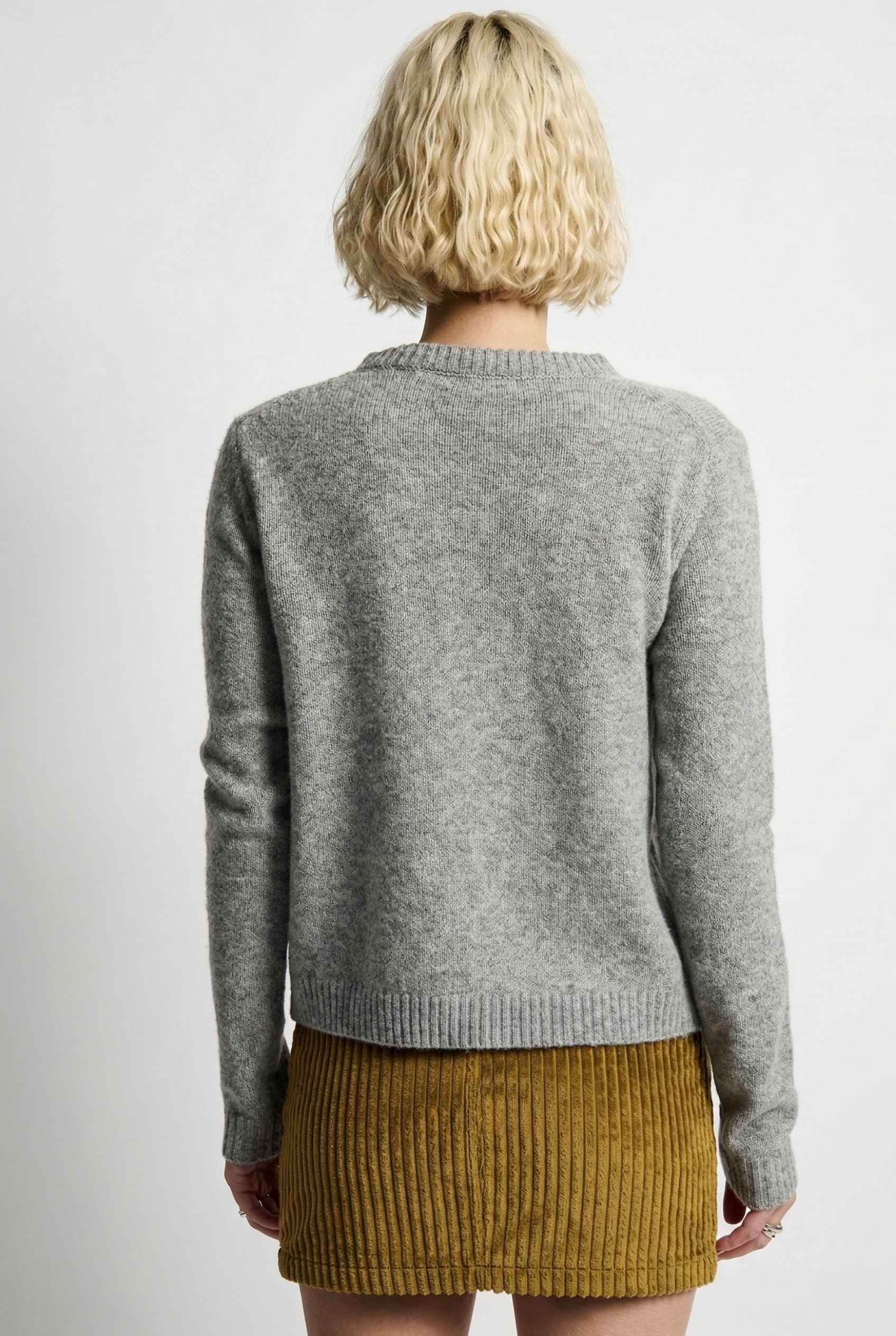 Model wearing Penelope Top in Grey Soft Wool-Blend Crew Neck Button-Up Cardigan with corduroy mini skirt