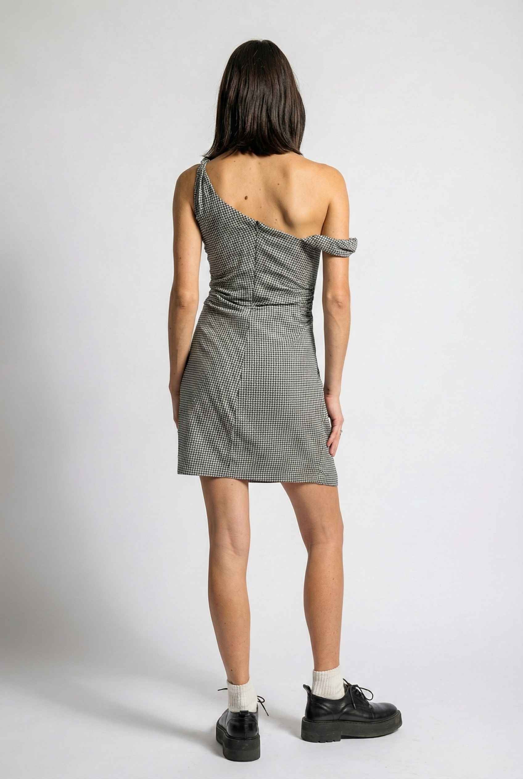 Woman wearing a Piper Mini Navy Gingham Off-Shoulder Dress on a white background