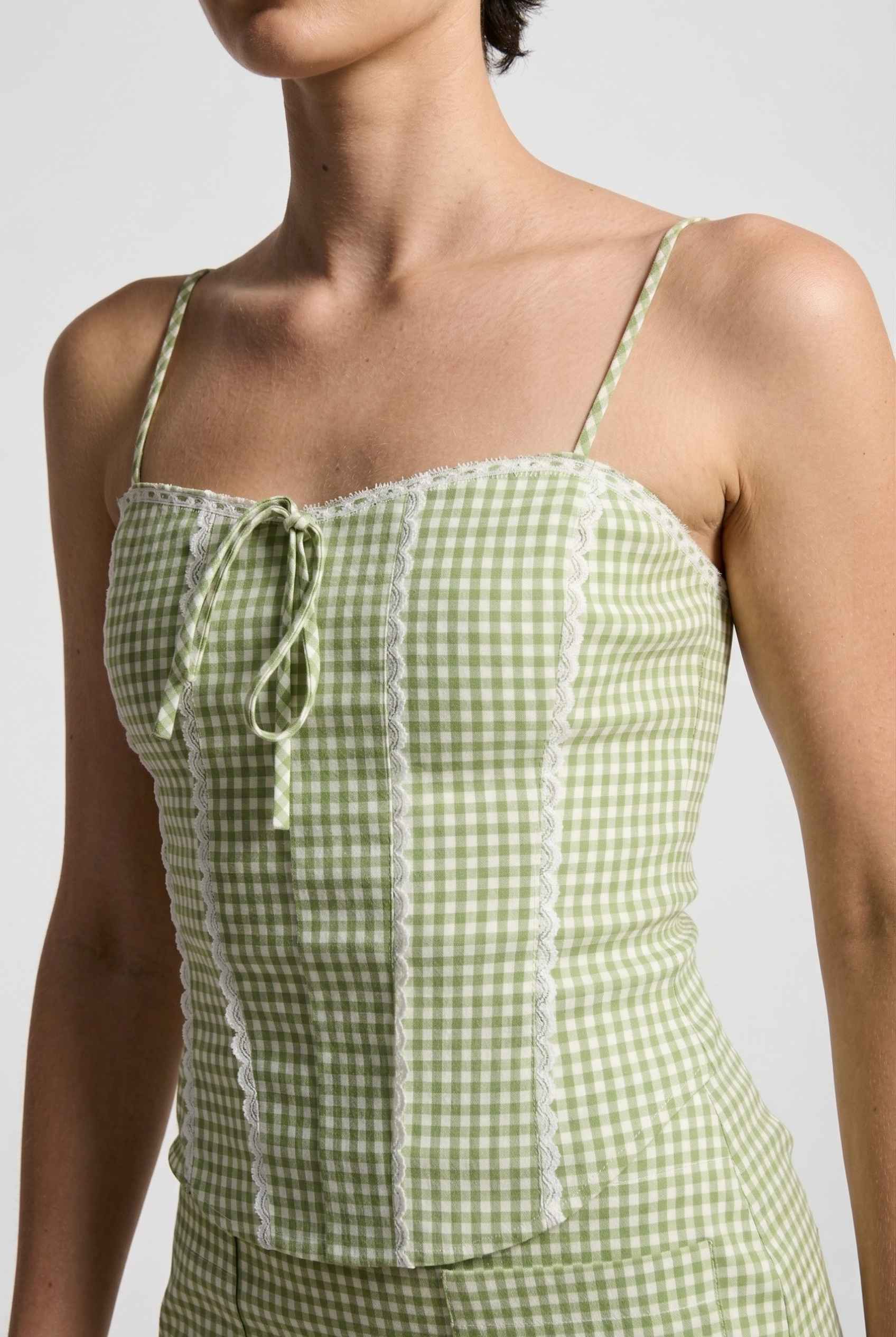 Piper Top Green Gingham Lace Trim Corset Cami worn by a woman on a plain background