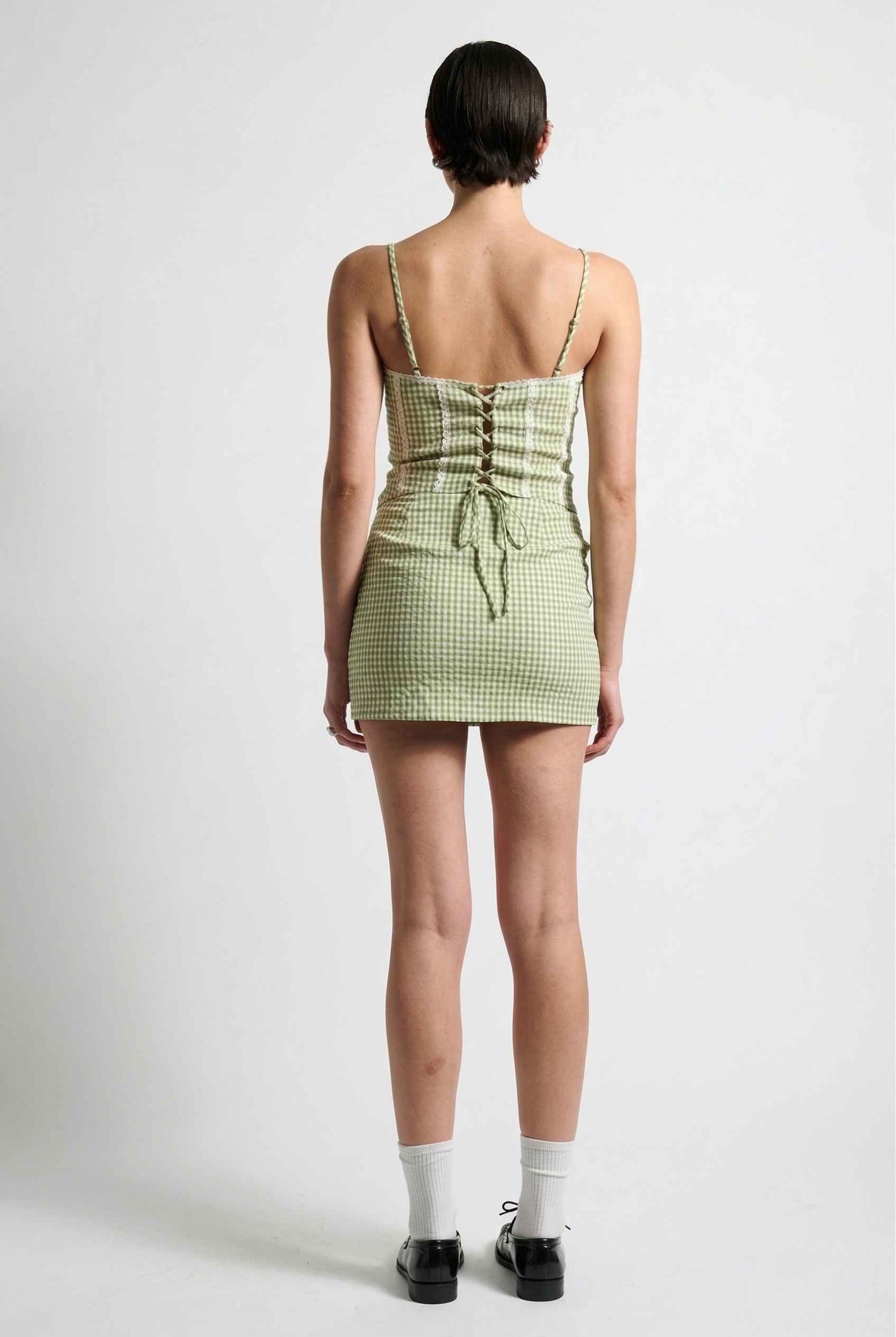 Person wearing a Piper Top Green Gingham Lace Trim Corset Cami on a white background