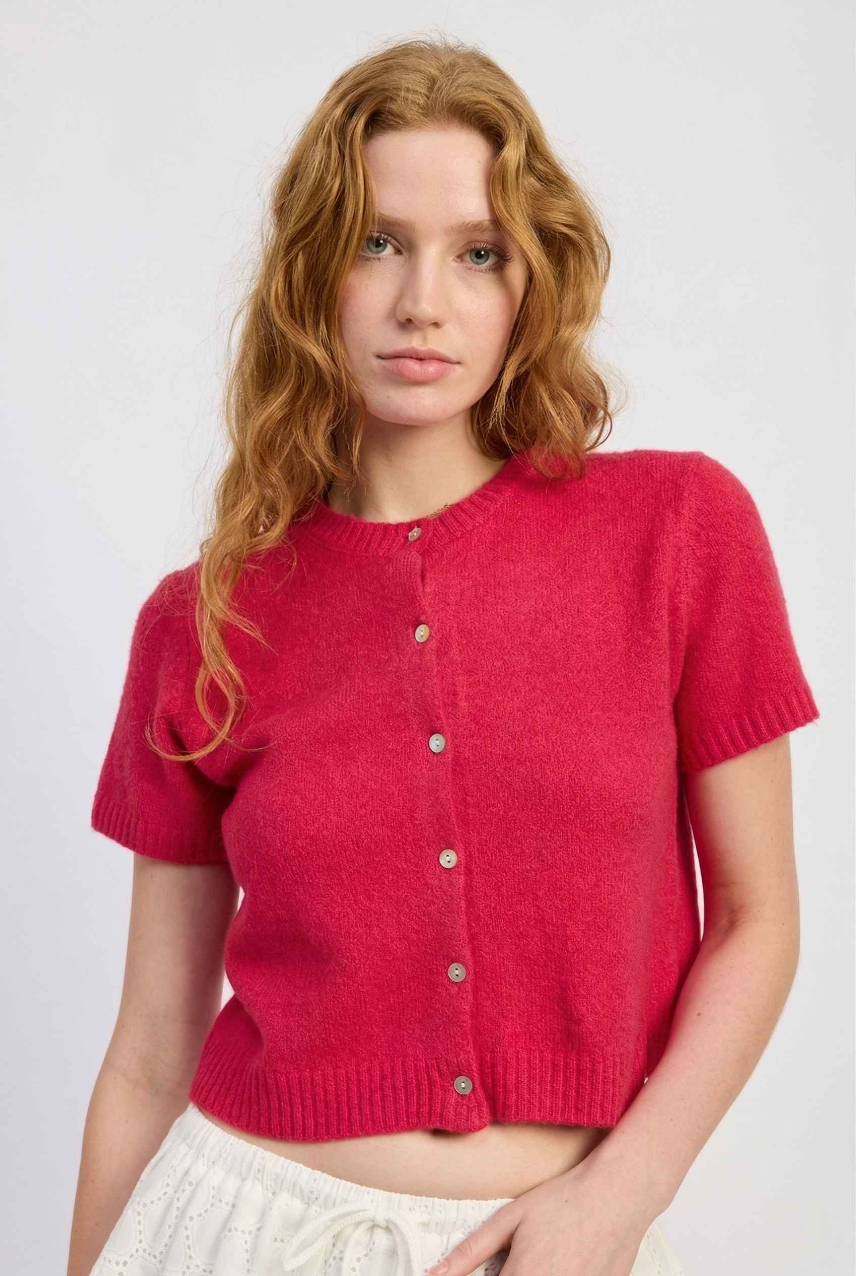 Model wearing Pippa Top in Red Short Sleeve Button-Up Cropped Cardigan paired with ruffle skirt