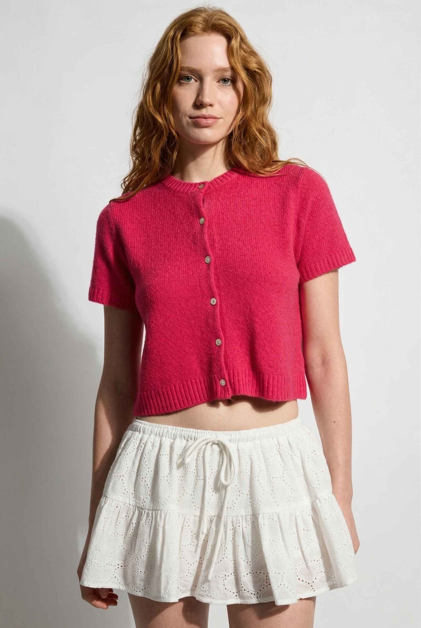 Model wearing Pippa Top in Red Short Sleeve Button-Up Cropped Cardigan paired with ruffle skirt