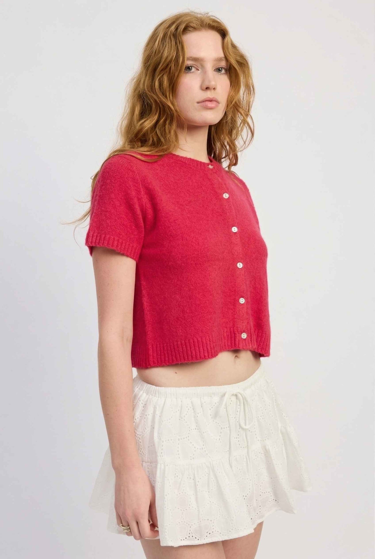 Model wearing Pippa Top in Red Short Sleeve Button-Up Cropped Cardigan paired with ruffle skirt 