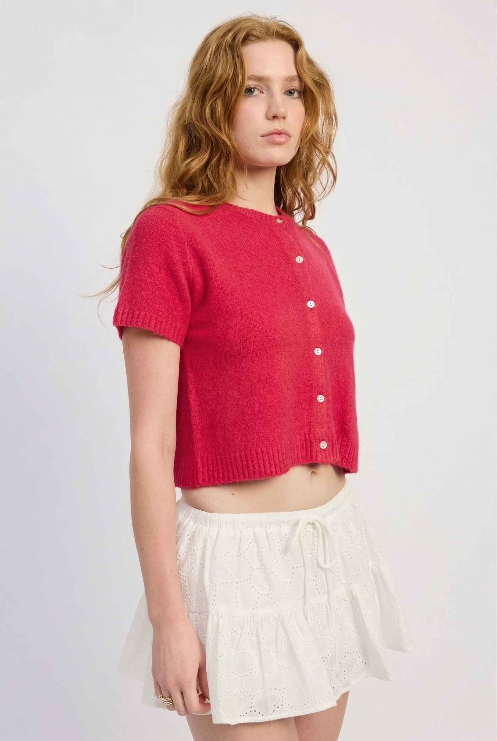 Model wearing Pippa Top in Red Short Sleeve Button-Up Cropped Cardigan paired with ruffle skirt 