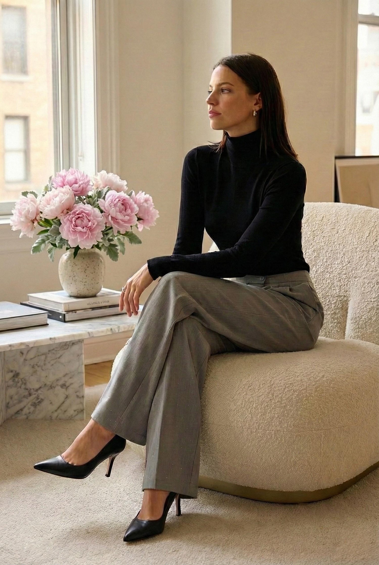 Model wearing Emory Park Pleated Wide Leg Trousers With Rhinestones in grey sitting in luxury apartment