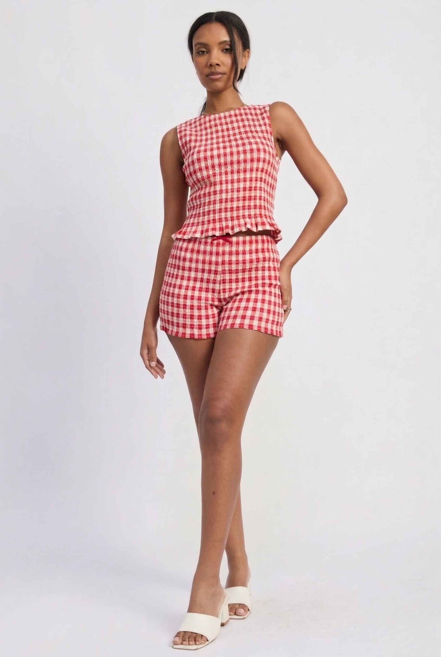 Woman wearing a rPoppy Top Red Gingham Smocked Sleeveless Knit on a white background