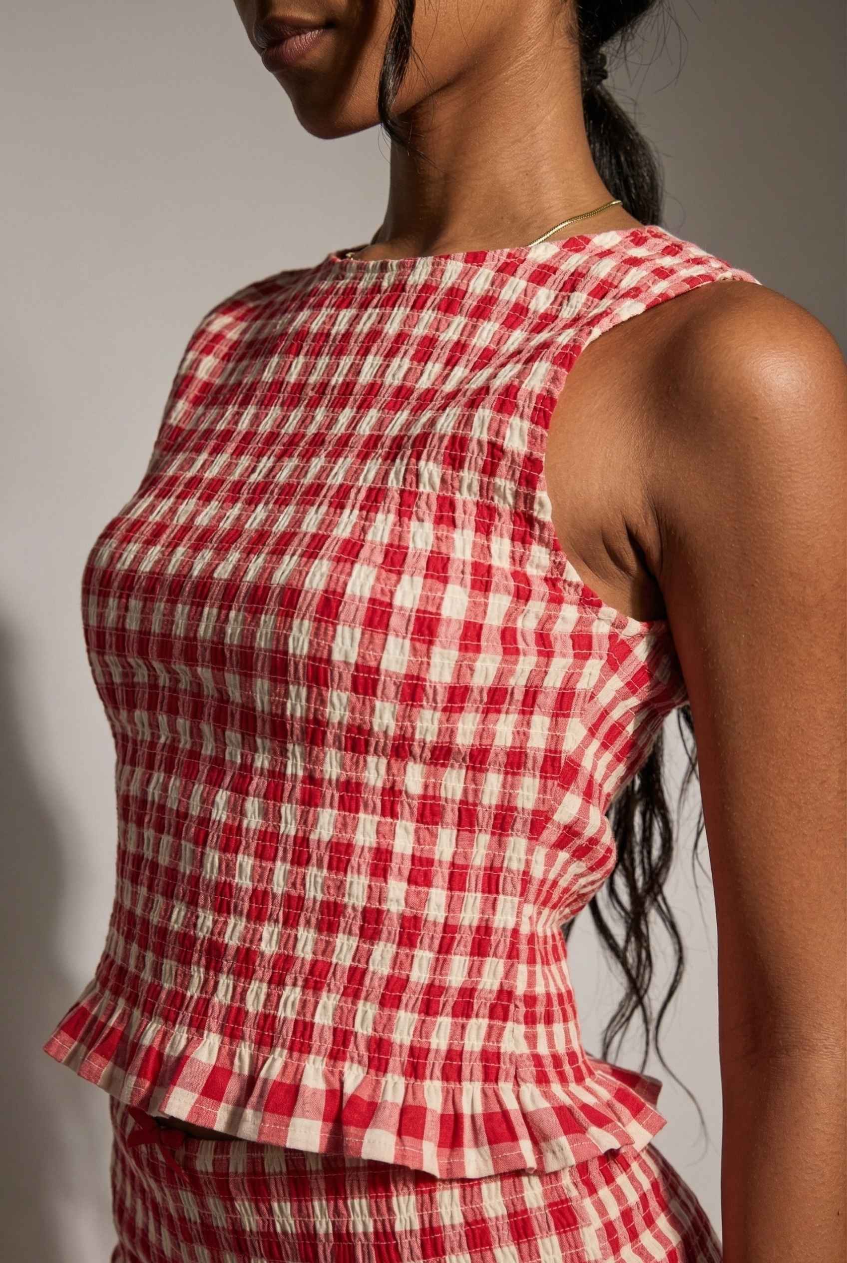 Poppy Top Red Gingham Smocked Sleeveless Knit worn by a woman against a neutral background