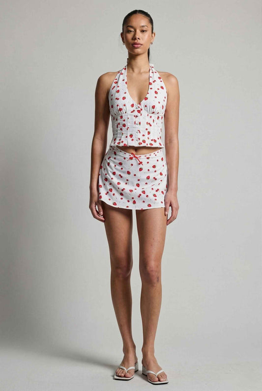 Model wearing Posie Skirt in Red Strawberry Print Cotton Mini Skirt with Bow paired with matching halter top and heeled sandals