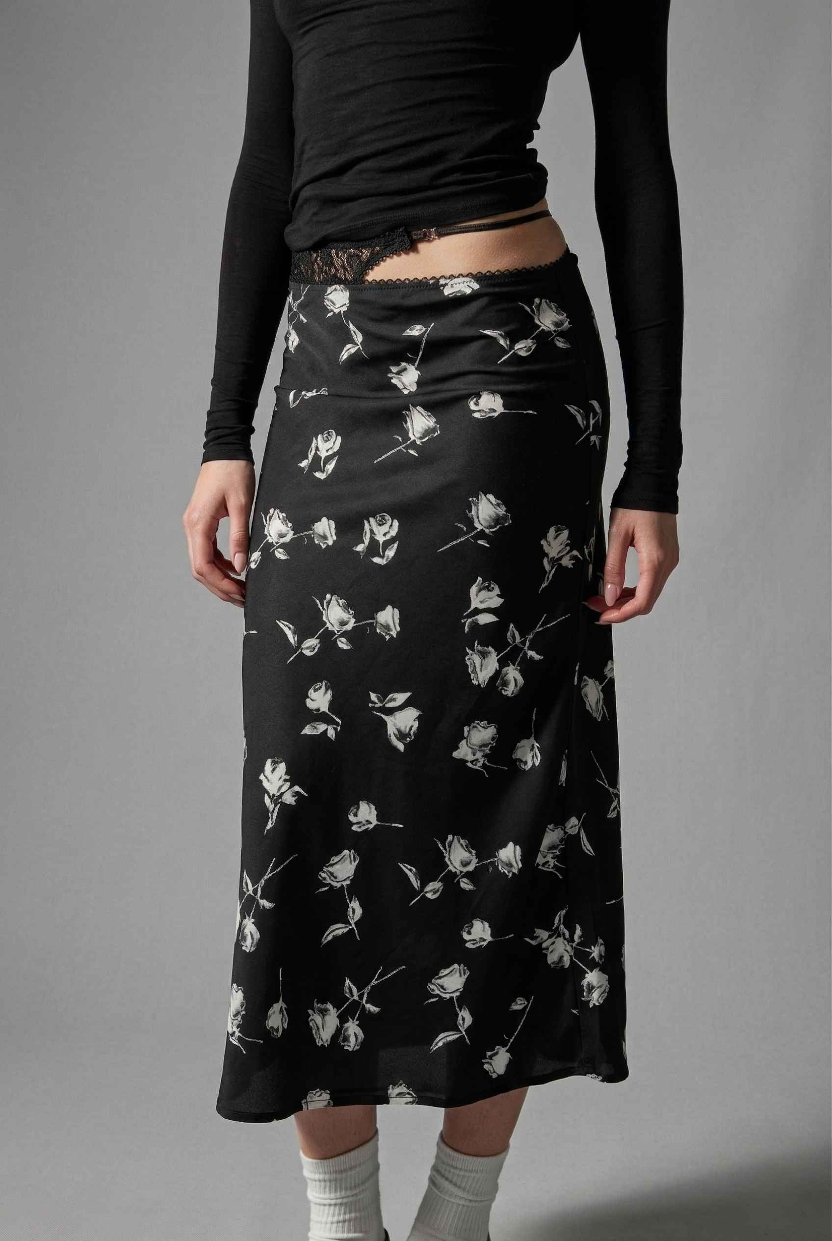 Model wearing Raven Skirt in Black Floral Satin Midi Skirt with Lace Waist paired with basic turtle neck and shiny loafers with tall socks