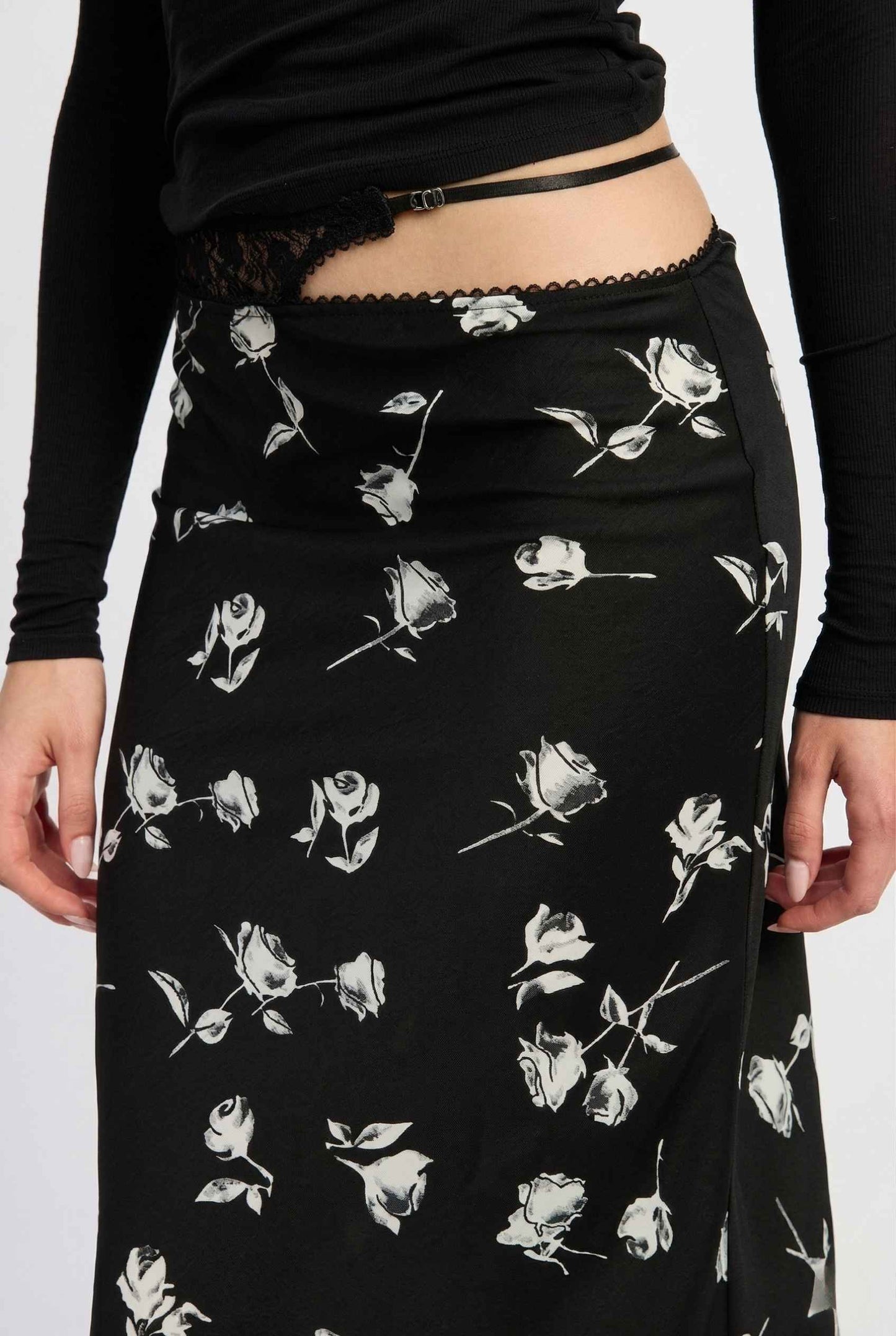 Model wearing Raven Skirt in Black Floral Satin Midi Skirt with Lace Waist paired with basic turtle neck close up floral pattern