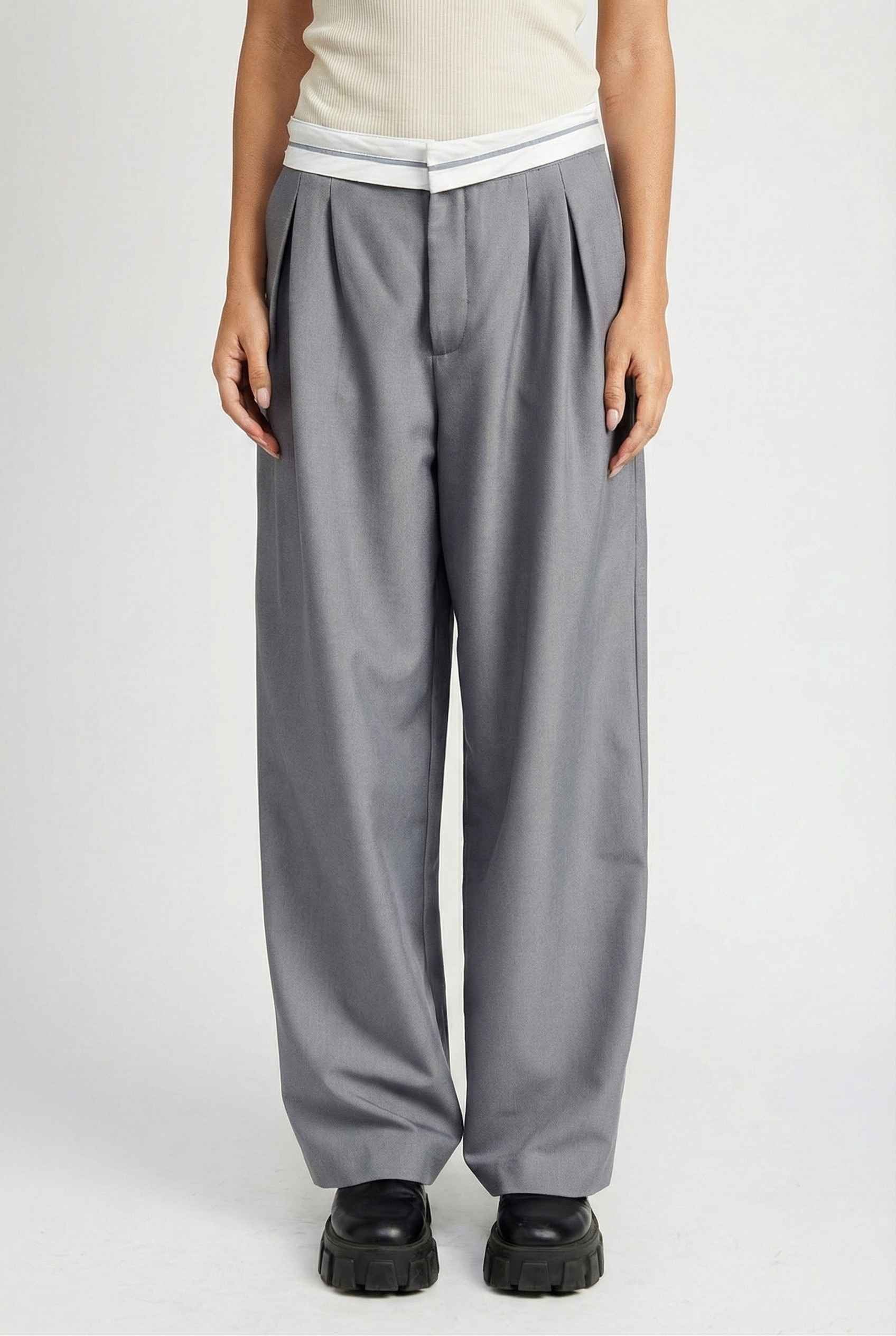 Model wearing Remi Pants in Grey Tailored Trousers with Contrast Fold-Over Waistband paired with basic tank and loafers