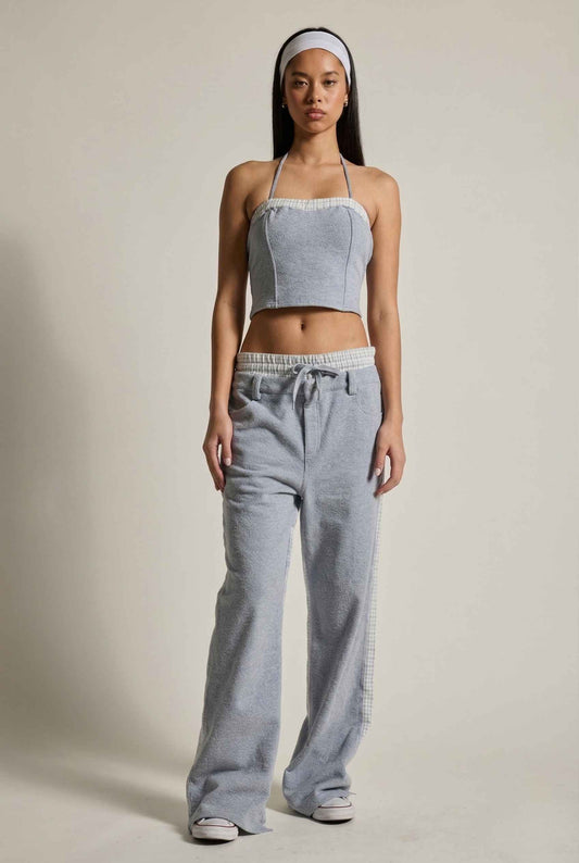 Woman wearing a Riley Top Light Blue Heathered Halter with Plaid Trim with wide-leg pants and a halter top on a plain background
