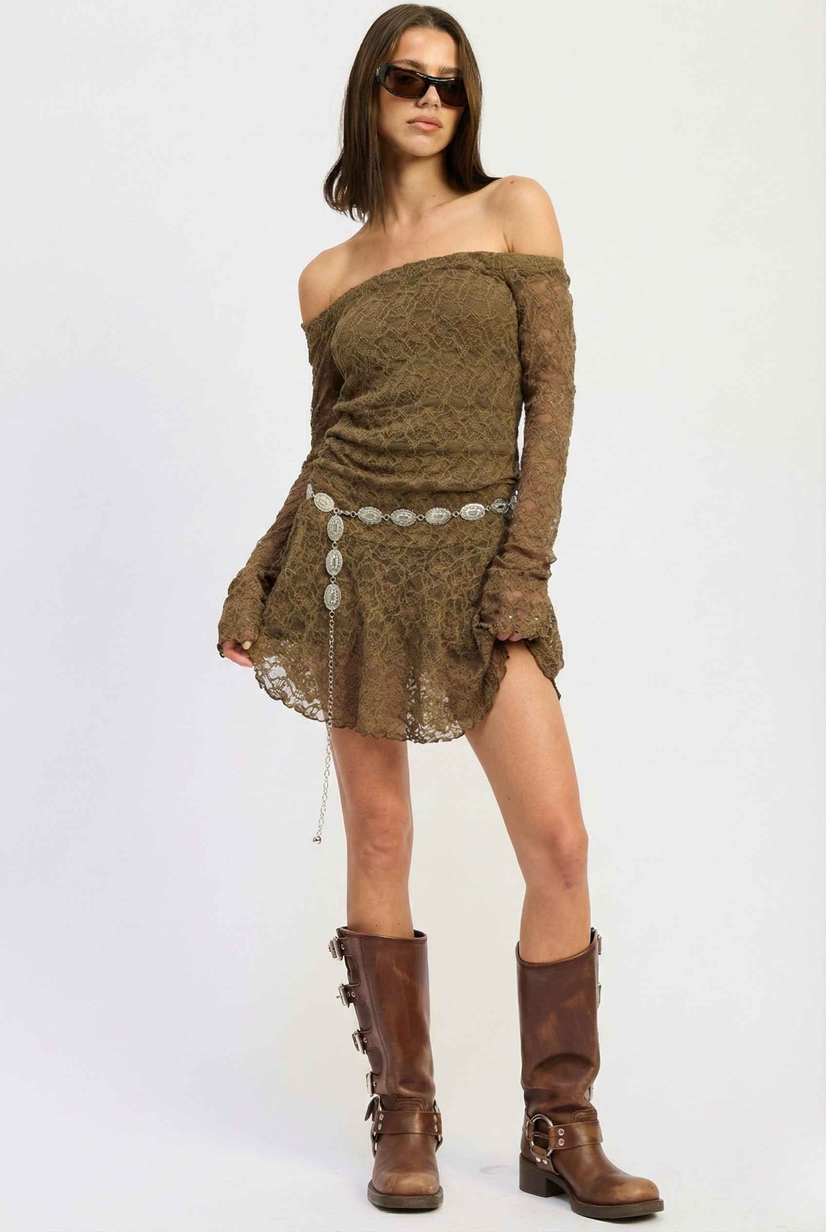 Woman wearing a Rowan Mini Olive Lace Off-Shoulder Long Sleeve Dress with long sleeves and brown boots on a white background