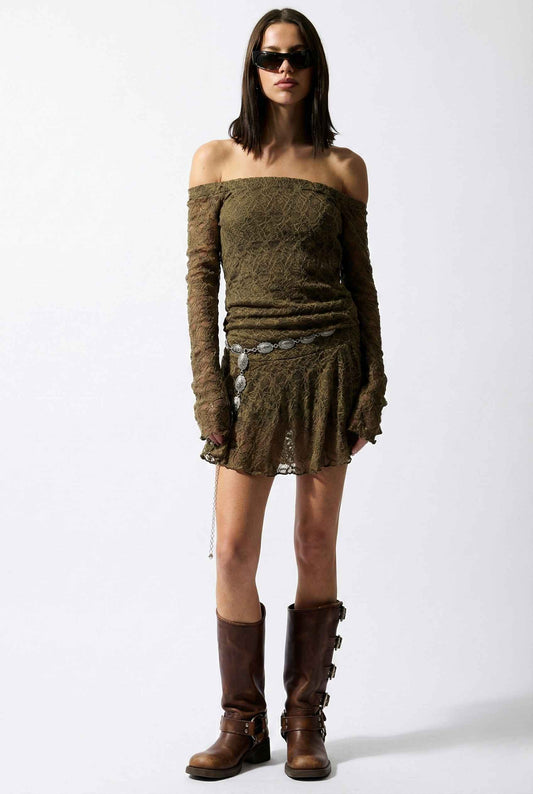 Woman wearing a Rowan Mini Olive Lace Off-Shoulder Long Sleeve Dress with long sleeves and brown boots on a white background