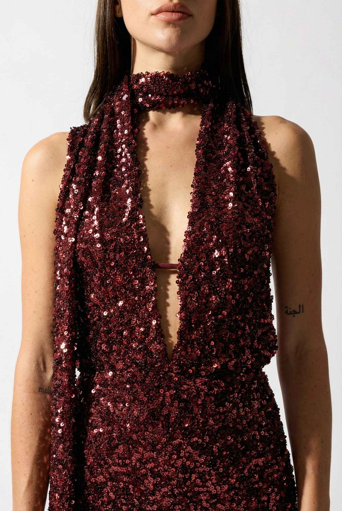 Woman wearing a Roxy Mini Cherry Sequin Halter Plunge Dress with a plain background
