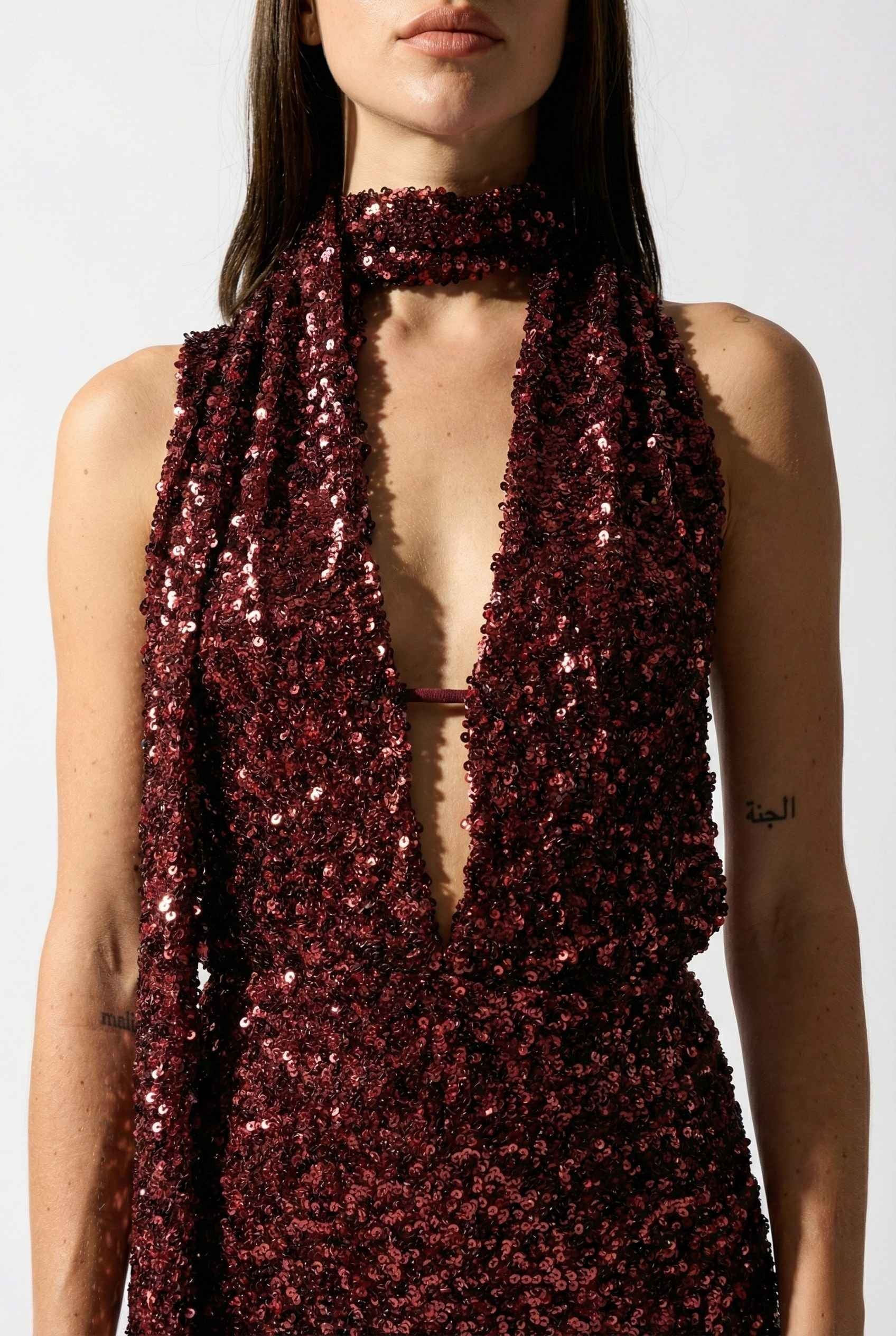 Woman wearing a Roxy Mini Cherry Sequin Halter Plunge Dress with a plain background