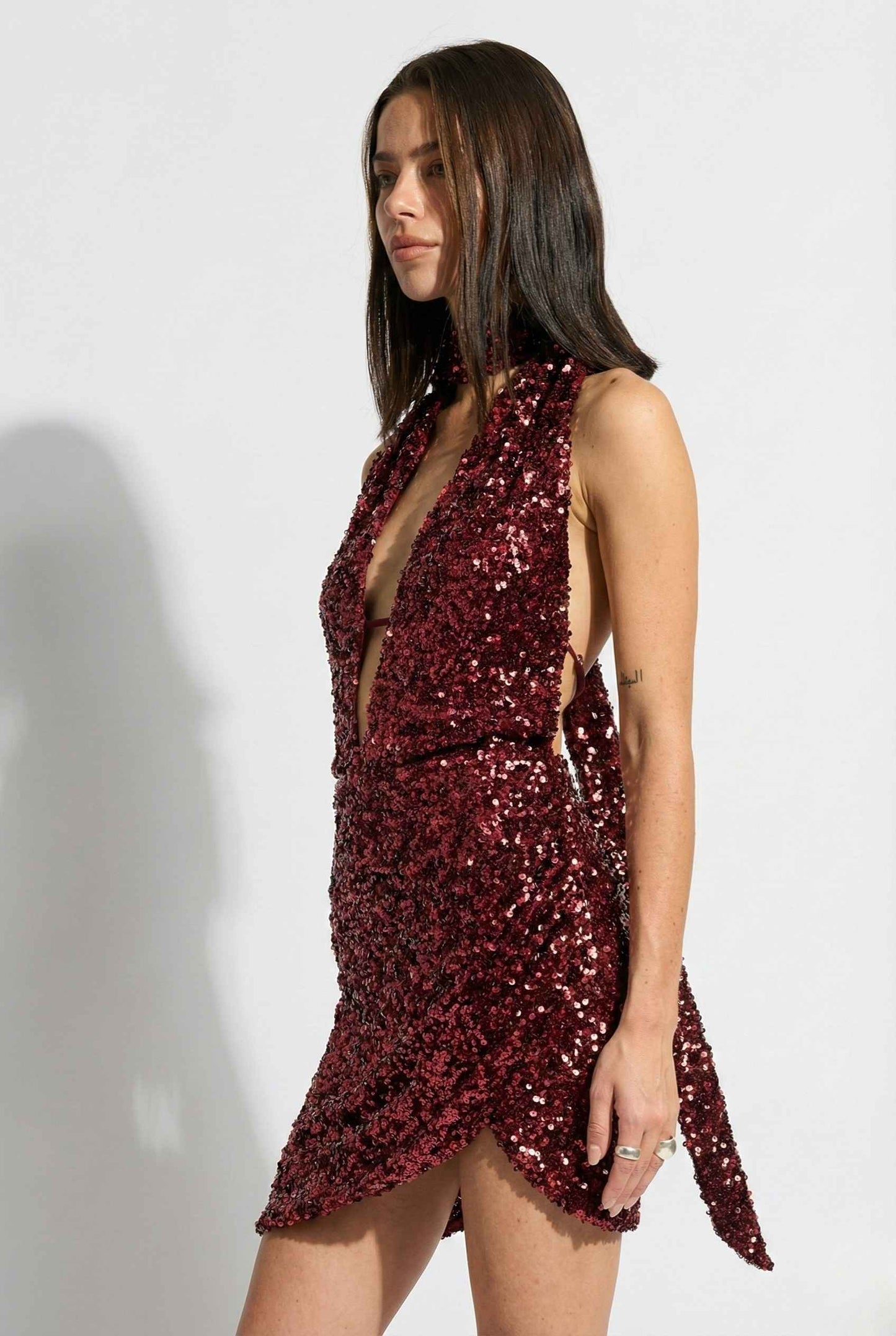 Woman wearing a Roxy Mini Cherry Sequin Halter Plunge Dress against a white background