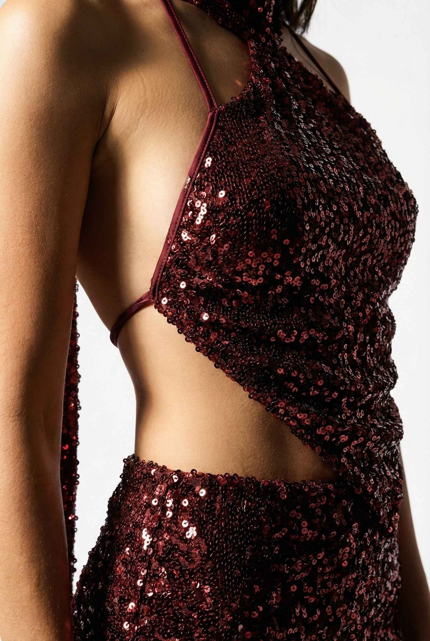 Close-up of a Roxy Mini Cherry Sequin Halter Plunge Dress with cut-out design on a white background