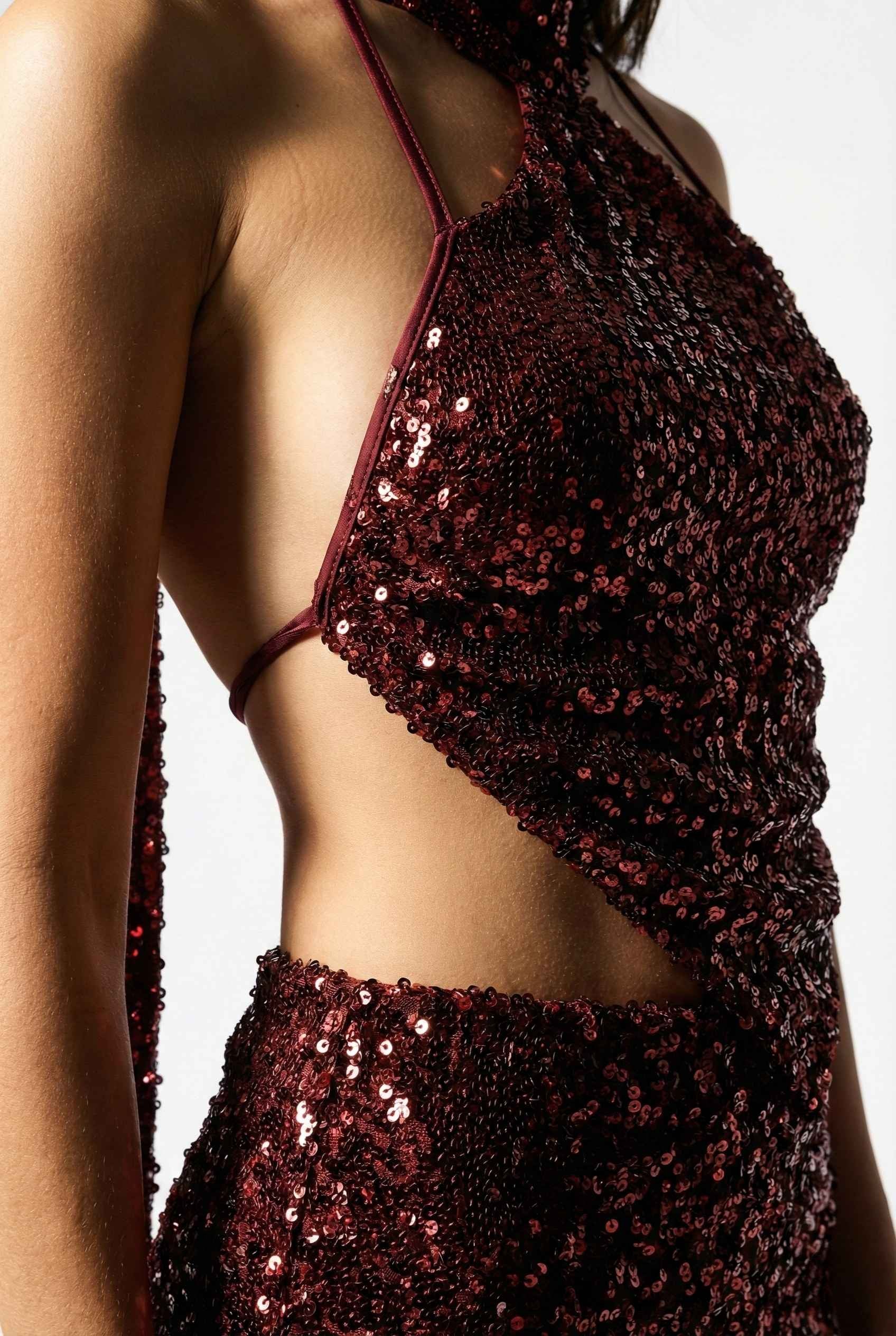Close-up of a Roxy Mini Cherry Sequin Halter Plunge Dress with cut-out design on a white background