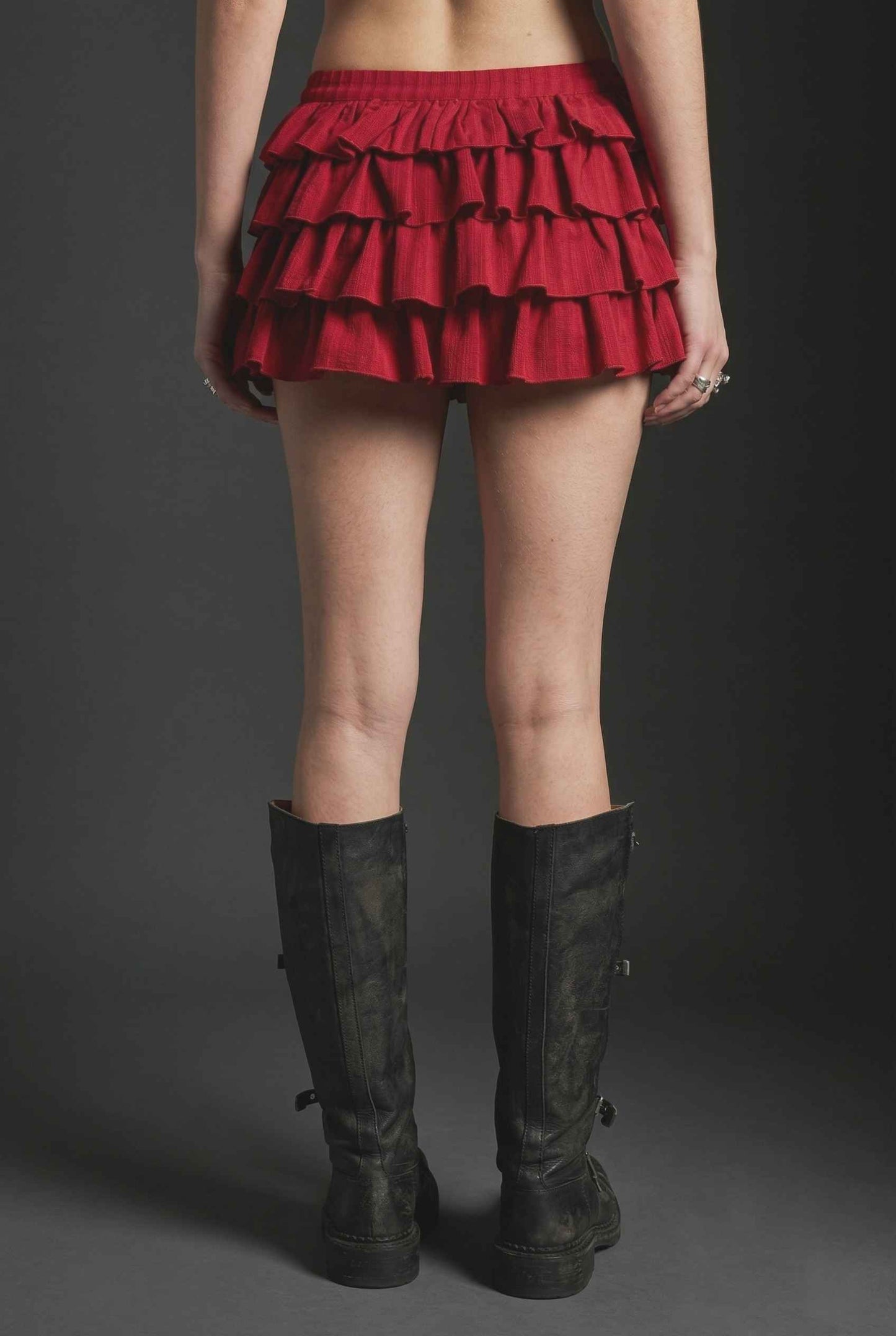Model wearing Roxy Skirt Tiered Ruffle Ra-Ra Mini Skirt in Red paired with matching tank top and with tall boots
