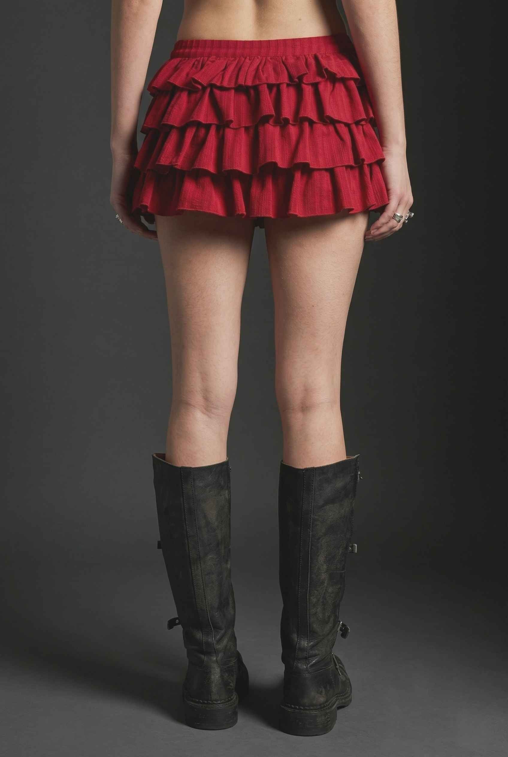 Model wearing Roxy Skirt Tiered Ruffle Ra-Ra Mini Skirt in Red paired with matching tank top and with tall boots
