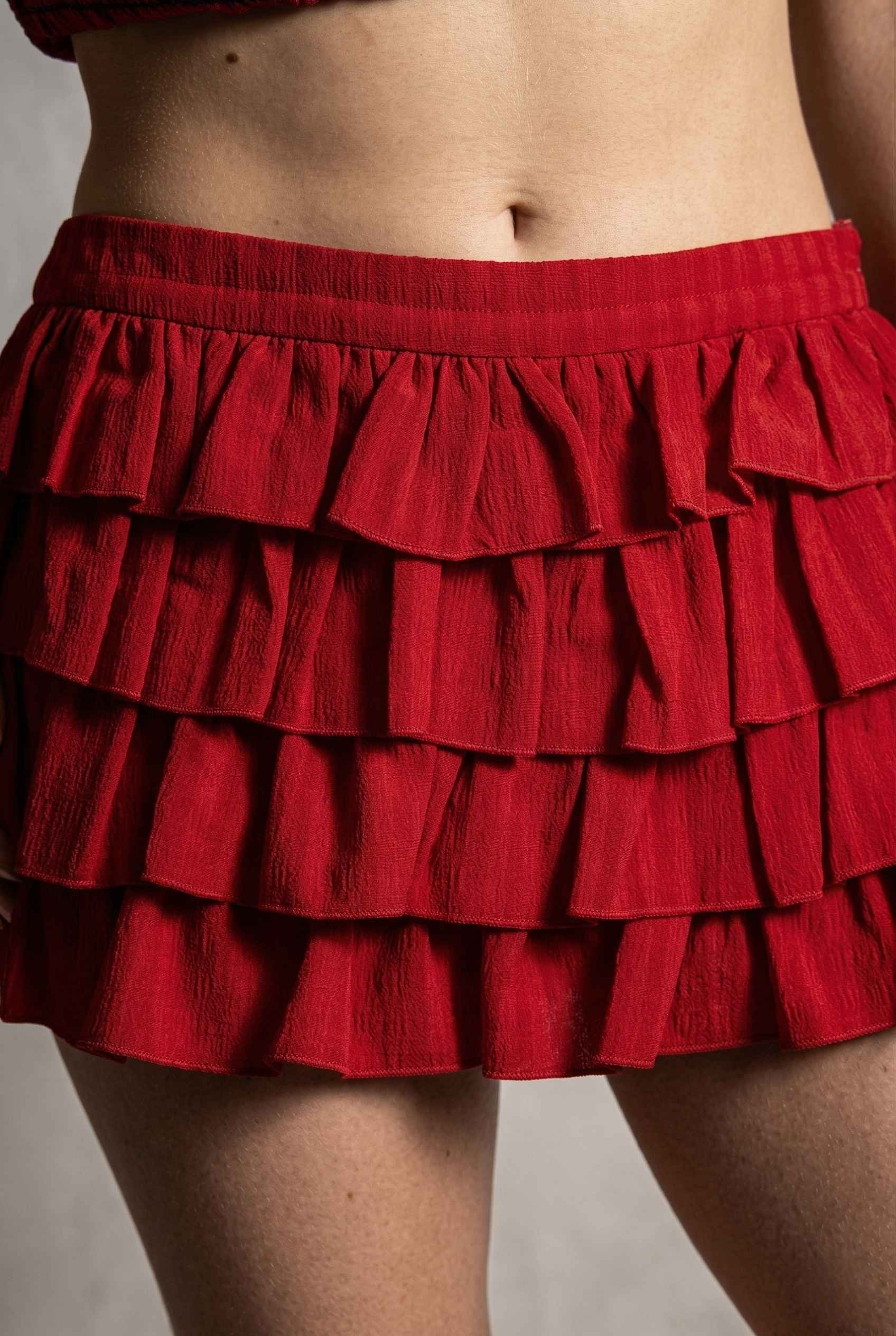 Model wearing Roxy Skirt Tiered Ruffle Ra-Ra Mini Skirt in Red close up delicate ruffle details