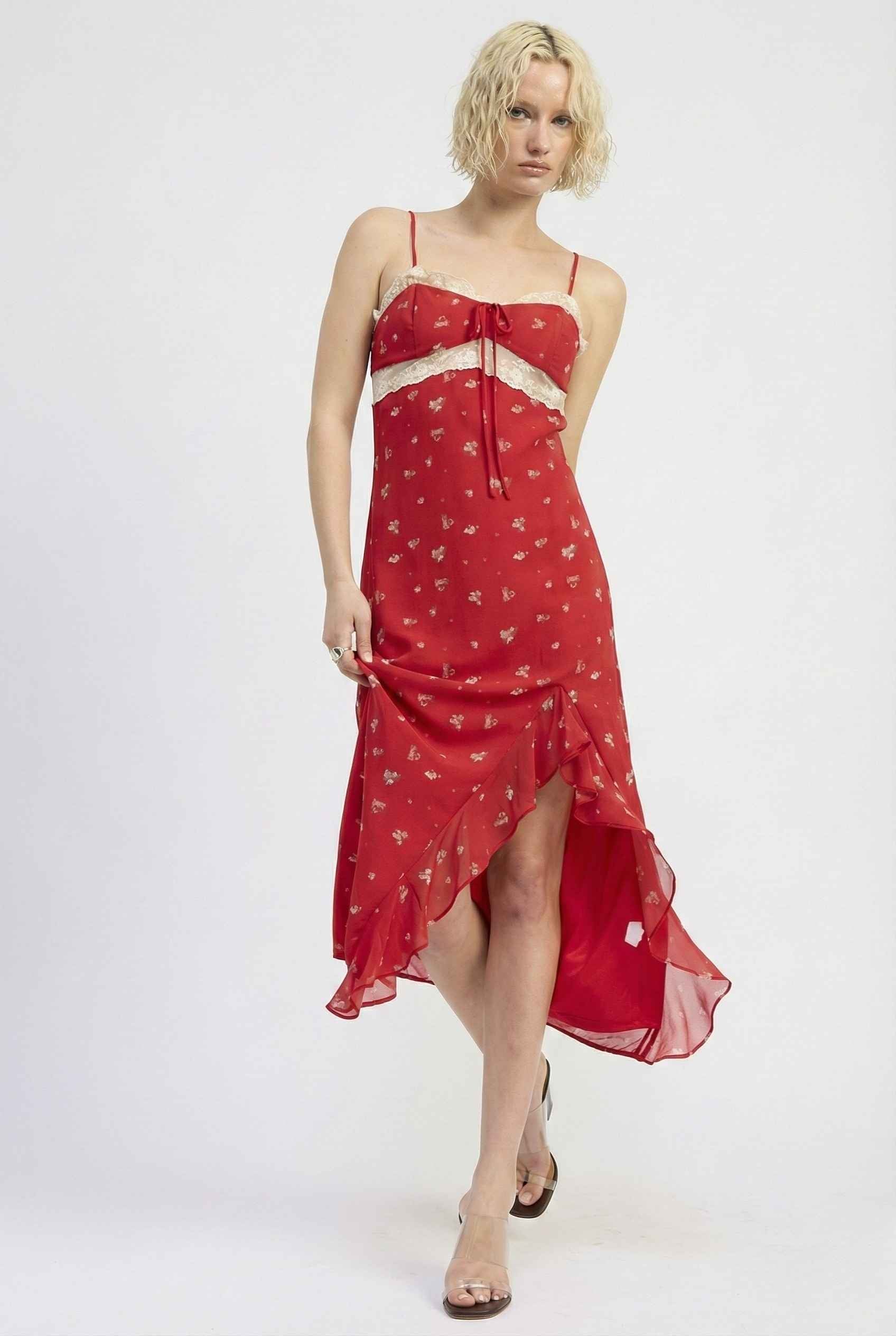 Woman wearing a Scarlett Maxi Red Floral Lace Trim Dress with white heart patterns on a white background