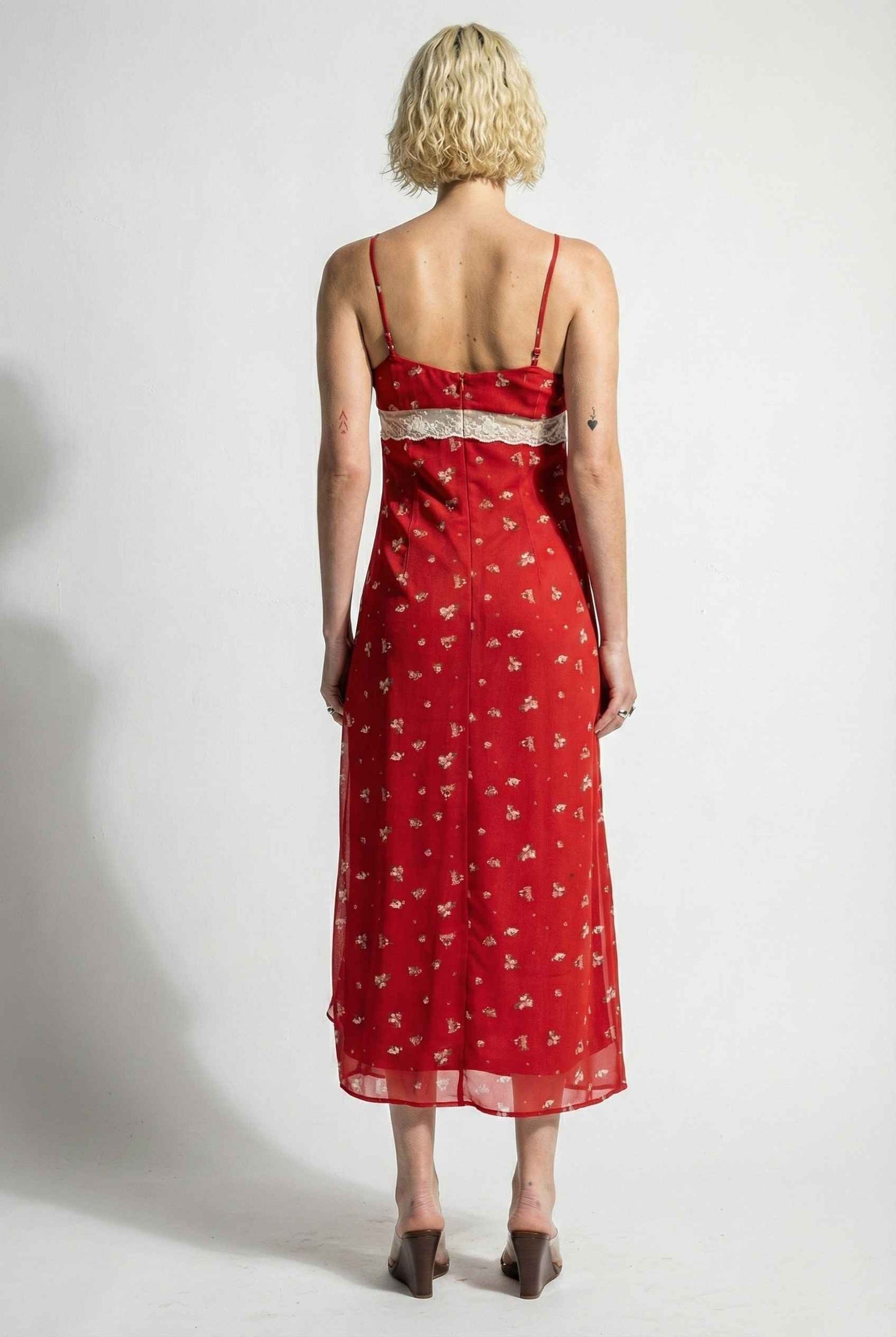Woman wearing a Scarlett Maxi Red Floral Lace Trim Dress with thin straps on a white background