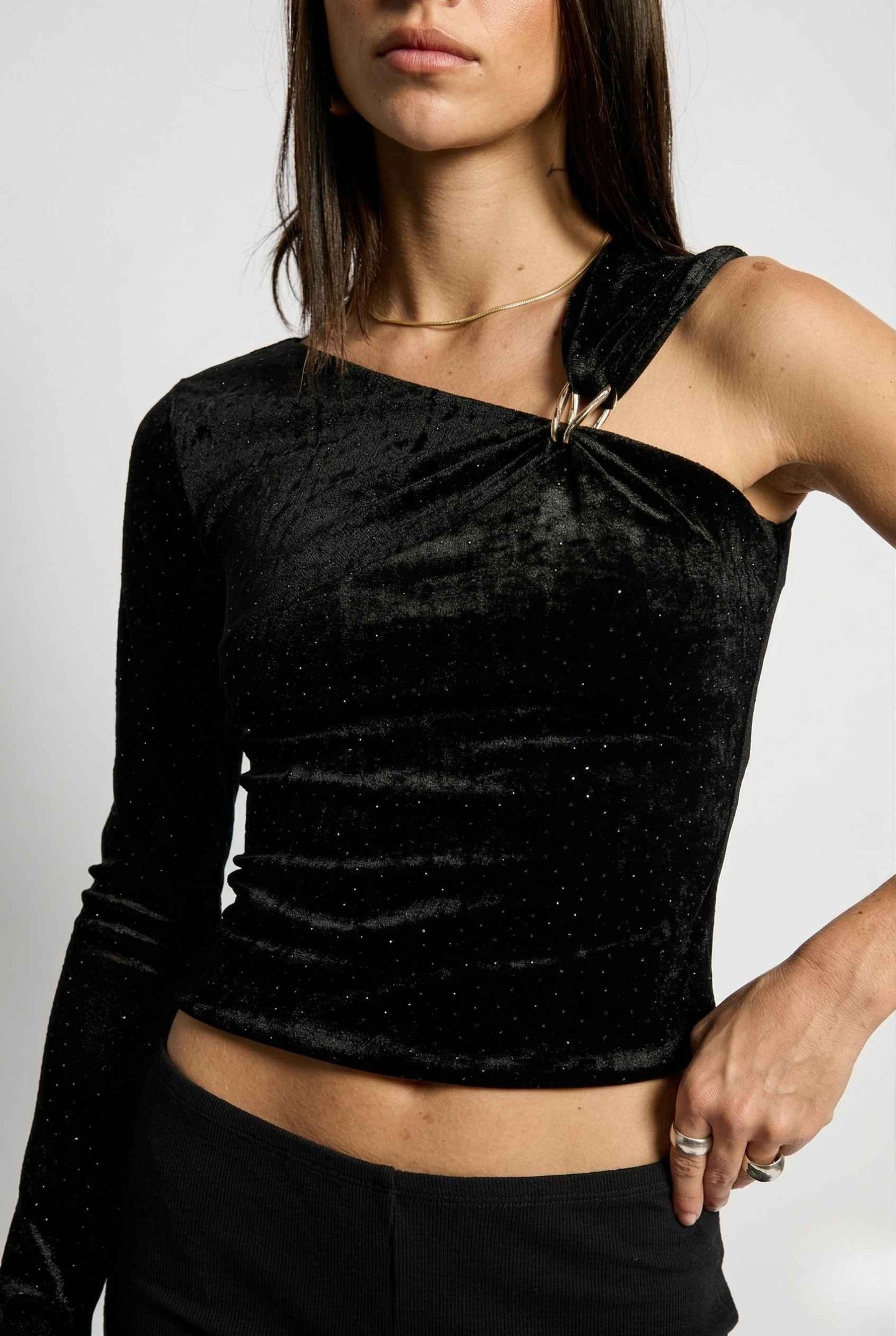 Selene Top Black Shimmer Velvet Asymmetrical Long Sleeve worn by a woman on a white background