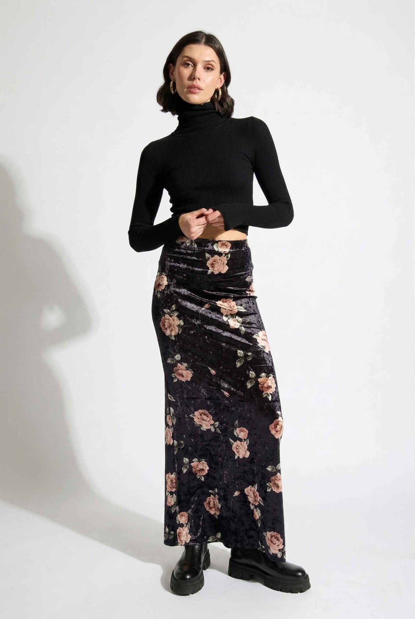 Model wearing Seraphina Skirt in Black Floral Stretch Velvet Column Maxi Skirt with sleek turtleneck and shiny loafers