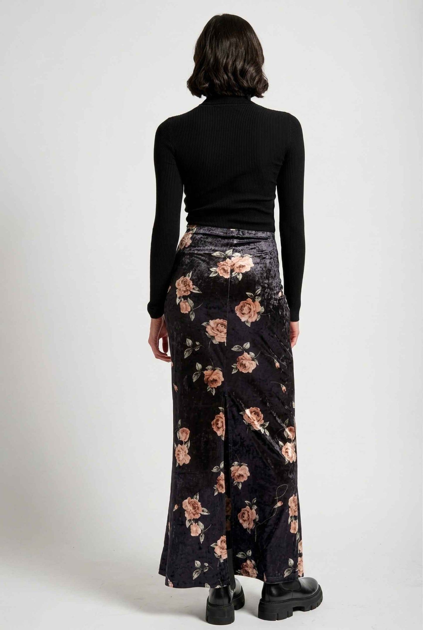 Model wearing Seraphina Skirt in Black Floral Stretch Velvet Column Maxi Skirt with sleek turtleneck and shiny loafers