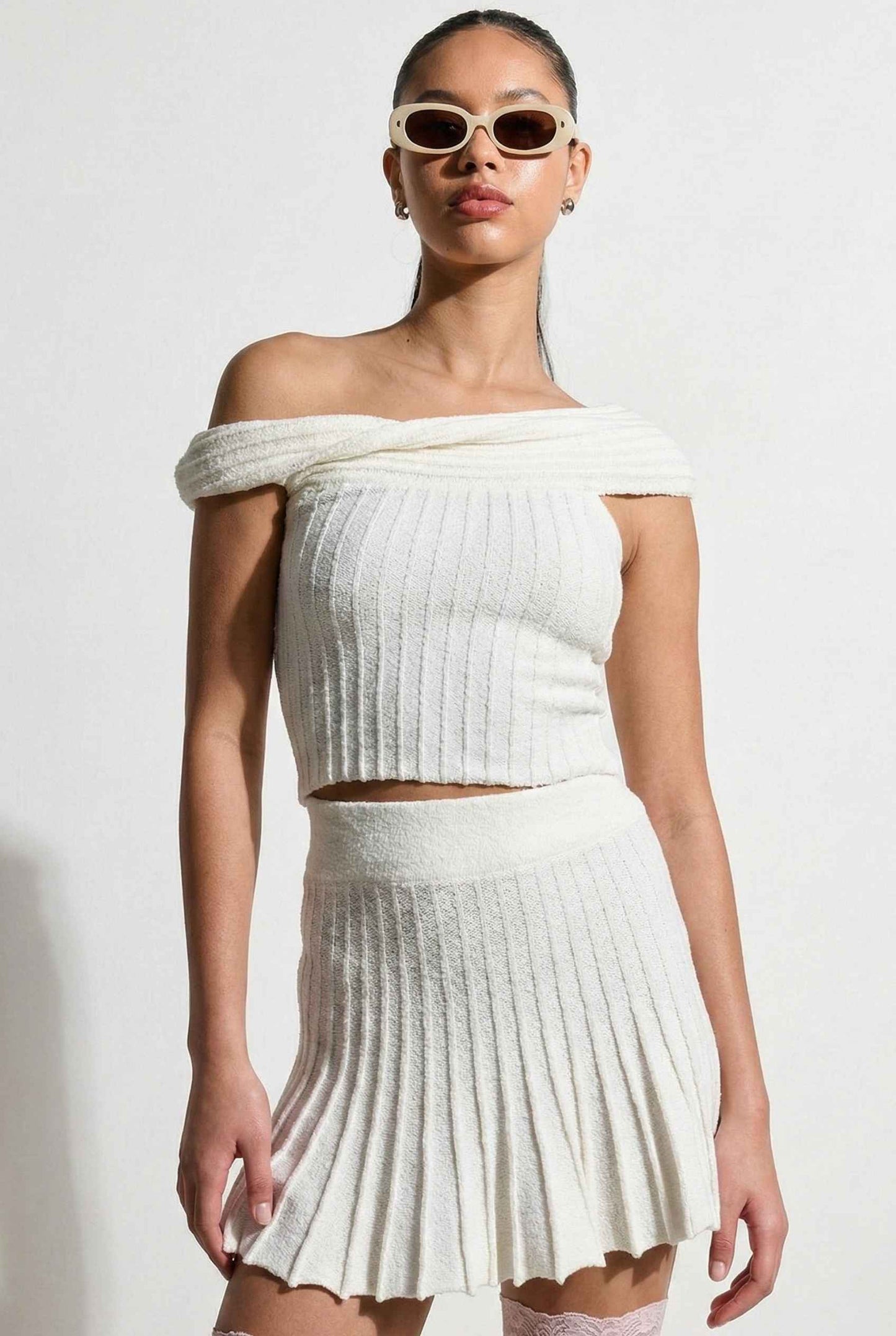 Model wearing Seraphina Top in White Ribbed Knit Twist-Front Off-Shoulder Top with matching mini skirt