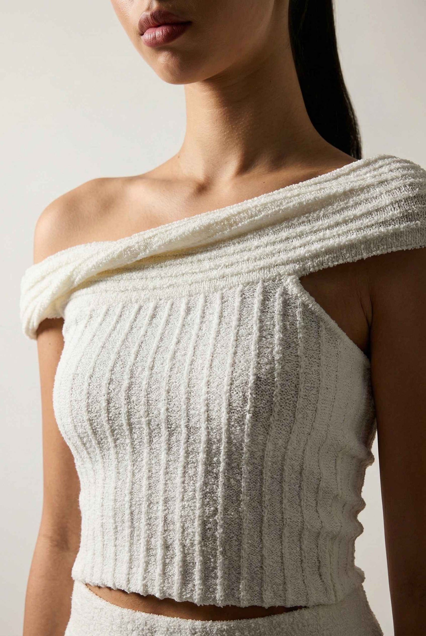 Model wearing Seraphina Top in White Ribbed Knit Twist-Front Off-Shoulder Top with matching mini skirt