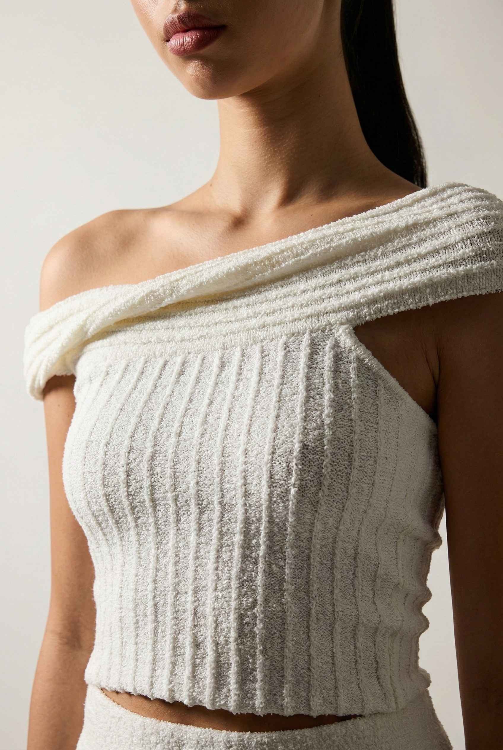 Model wearing Seraphina Top in White Ribbed Knit Twist-Front Off-Shoulder Top with matching mini skirt