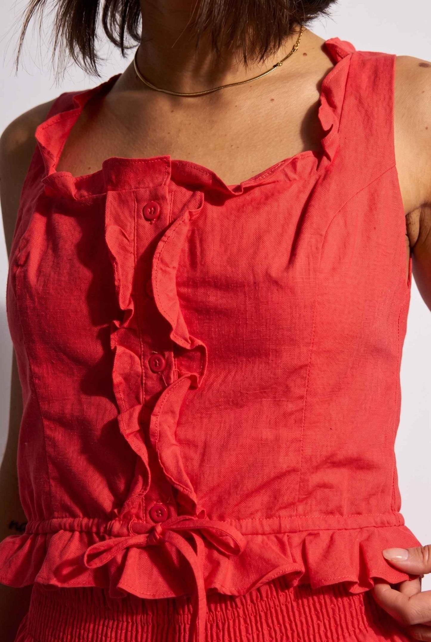 Model wearing Shay Ruffle Button-Front Top Cotton-Linen Tank Top in Red close up ruffle trim detail