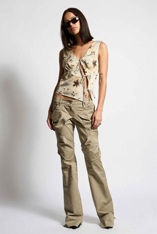 Woman wearing a Sienna Top Beige & Mocha Floral Tie-Front Split Hem Cami and beige pants on a white background