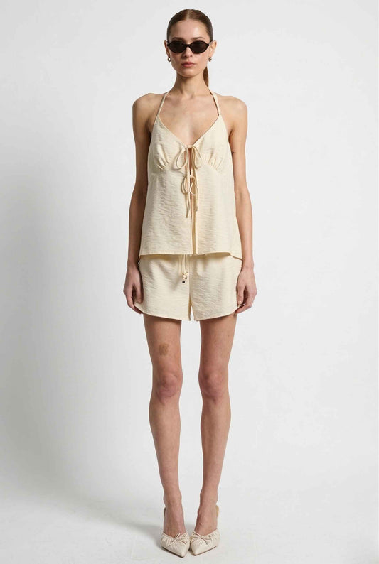 Woman wearing a Sienna Top Cream Tie-Front V-Neck Halter Tank with a zipper on a white background