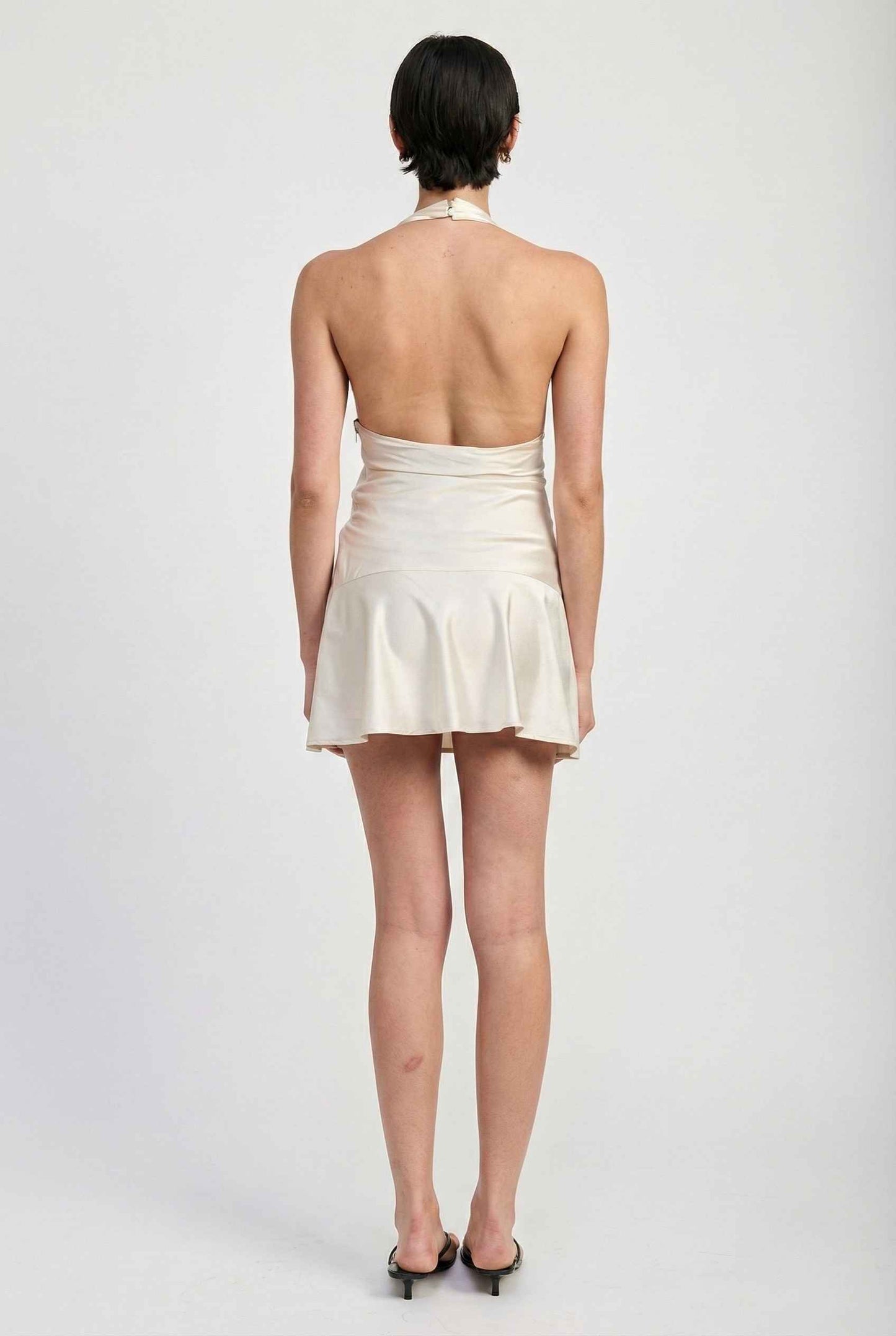 Woman wearing a Simone Mini Ivory Satin Halter Lace Trim Dress on a plain background